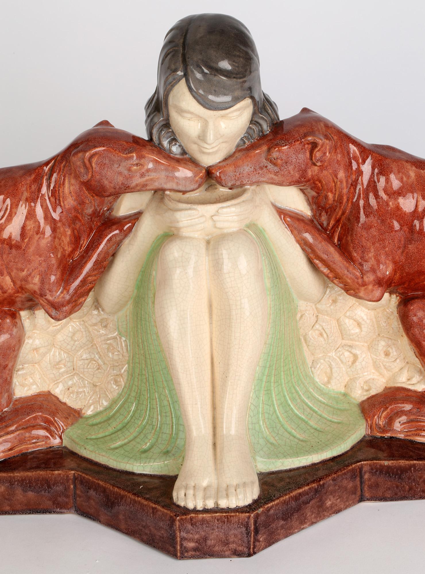 An exceptional and large impressive French Art Deco earthenware figural study of a seated young naked girl sat between two Borzoi hounds by Armand Godard produced by Marcel Guillard (1896-1932) for Editions Etling, Paris and dating from around 1925.