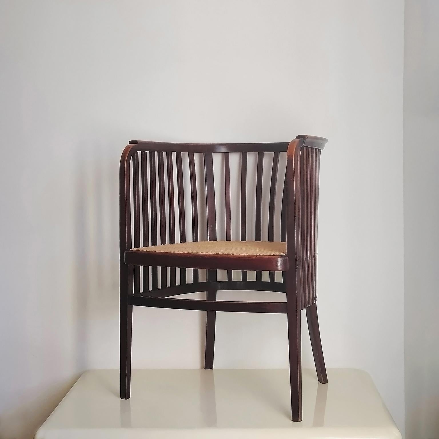 Fauteuil unique fabriqué par Gebruder Thonet en 1909 et conçu par l'architecte viennois Marcel Kammerer.
Ce fauteuil Thonet présente une structure en hêtre cintré teinté brun foncé avec une assise en cannage. 

Le Label et le cachet du fabricant