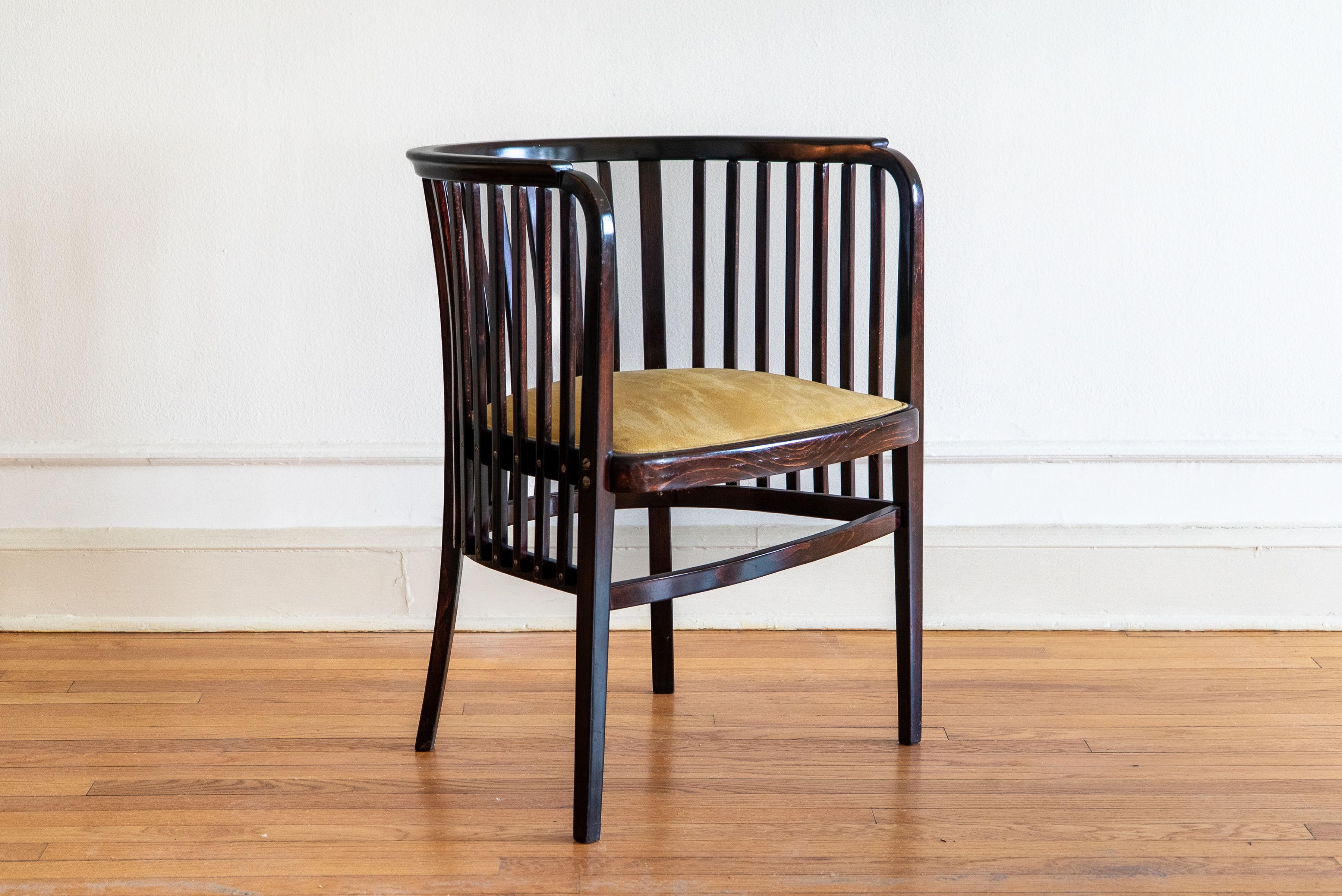 A striking example of early 20th-century Viennese design, this armchair is attributed to Marcel Kammerer and executed by Gebrüder Thonet in Austria circa 1910. 

The chair features elegantly bent beechwood in a rich dark stain, forming a continuous,