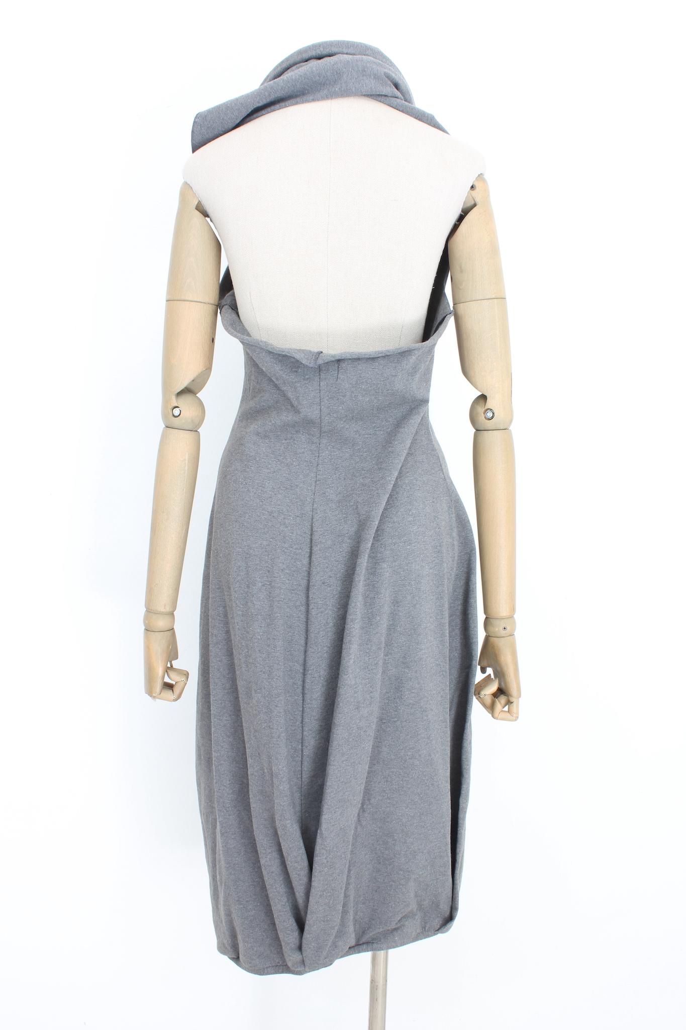 The Marcel Marongiu sack dress from the 2000s is a casual yet stylish piece made of comfortable gray cotton fabric. It features a unique scarf closure that wraps around the neck, adding a touch of elegance to the simple design. The dress has a