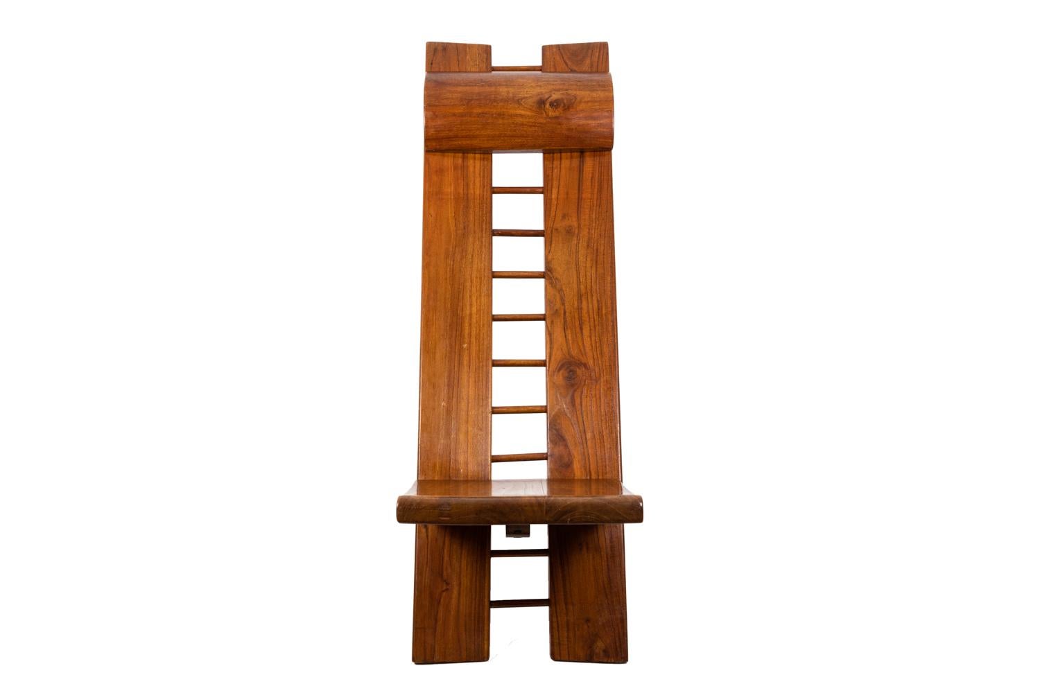 Marcel Ramond, firmado.
Sillón de estilo africano compuesto por dos tablas entrelazadas. Respaldo compuesto por dos tablas unidas entre sí por una escala sobre la que se fija un soporte de cabeza móvil de forma curva. Asiento móvil que forma una