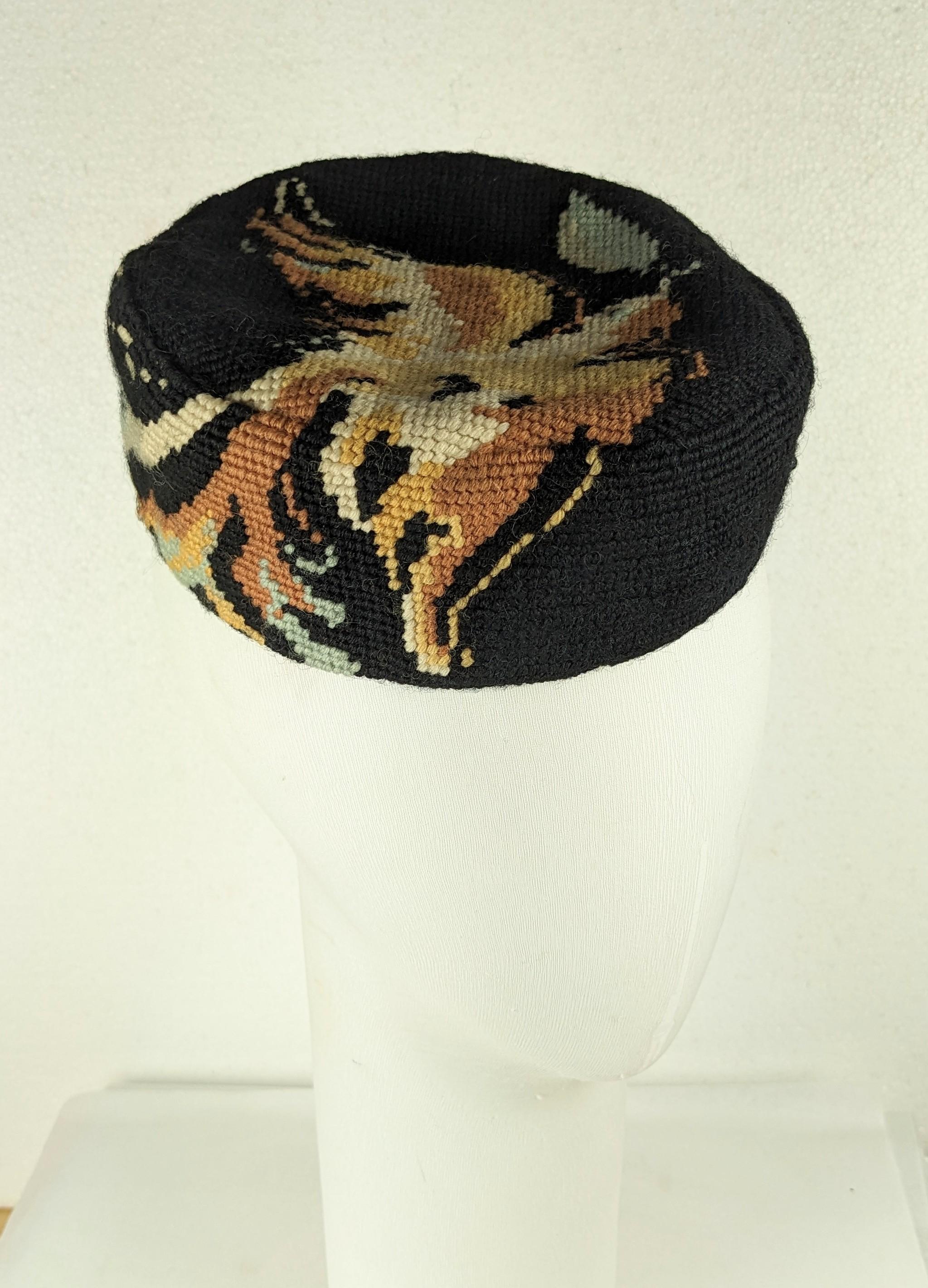 Marcel Vertes design hand cross stitched pillbox hat circa 1940. Of a flying dove with wings outstretched holding an olive leaf in its beak. Black background with the dove in ivory with autumnal color accents lined in black sateen. 1940's France.