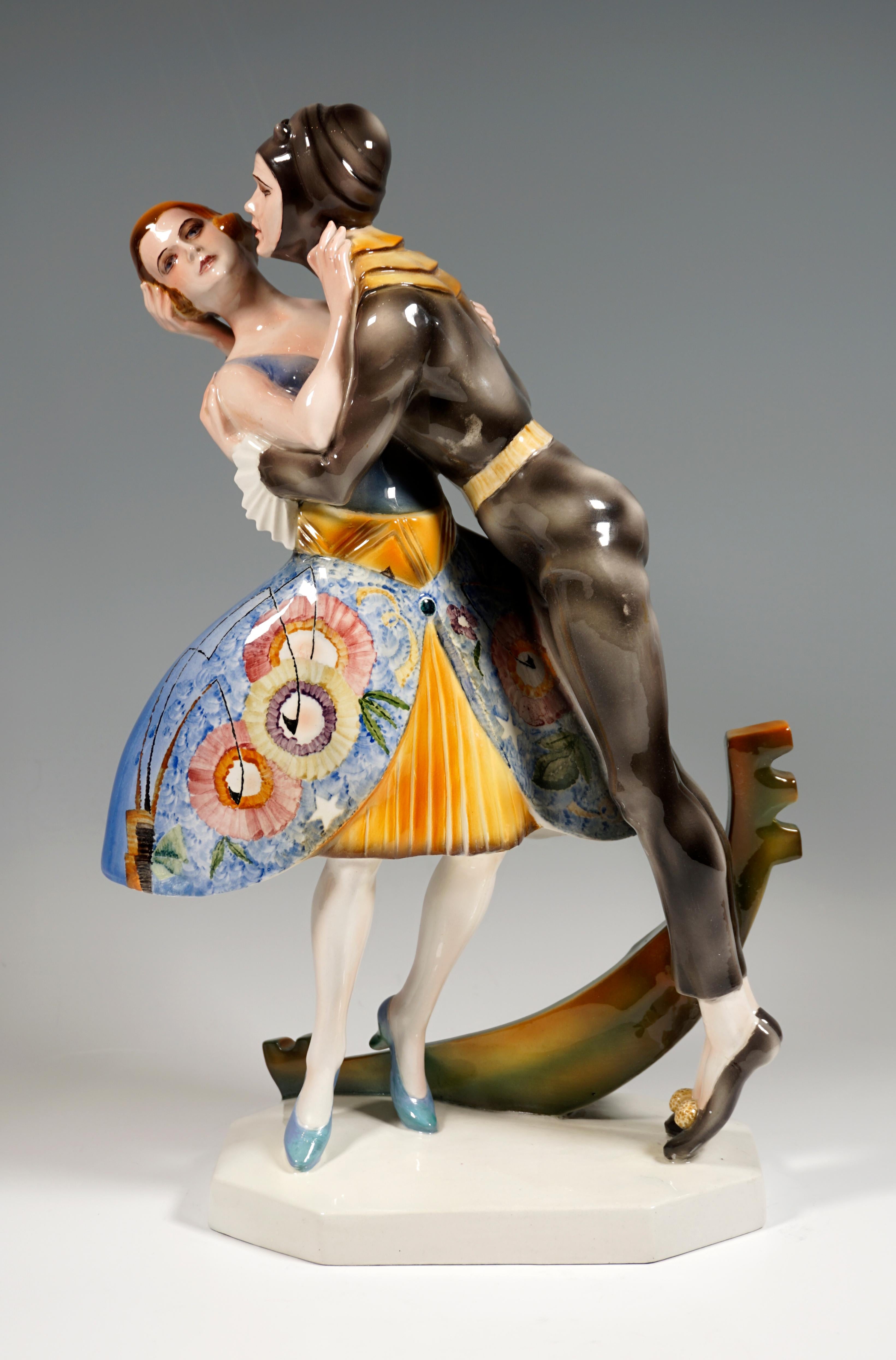 Rare Marcell Goldscheider ceramic figurine group.
Standing, embracing, disguised lovers: the galan in a tight, dark gray suit with a yellow collar and hood with antennae bends over to his beloved in a blue and yellow costume with an insect