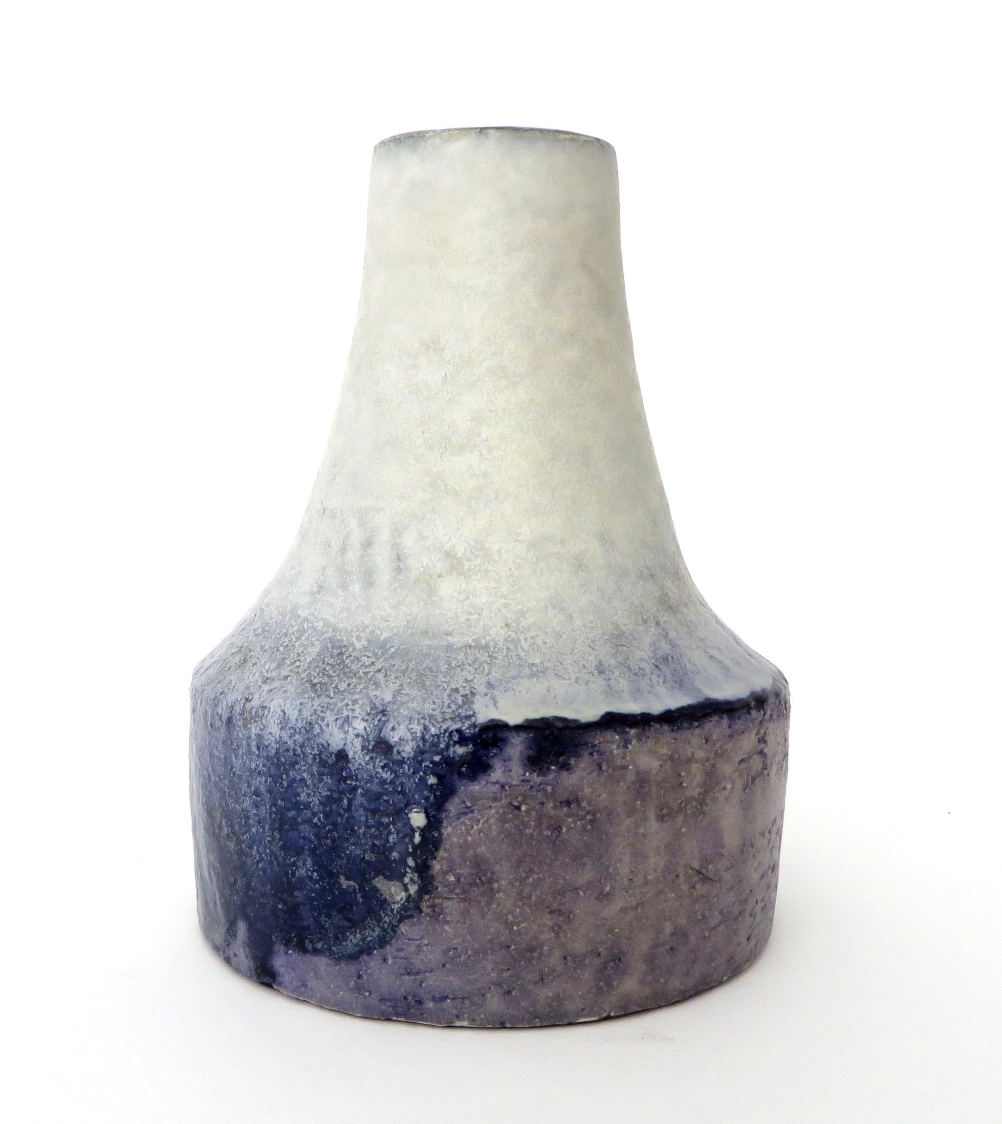 Beautiful and unusual color palette and painterly glazed ceramic vase by Marcello Fantoni.
The cream body with blue edged rim and then the blue breaking in nice waves down the middle of the vase and ending in light purple make this a very unusual