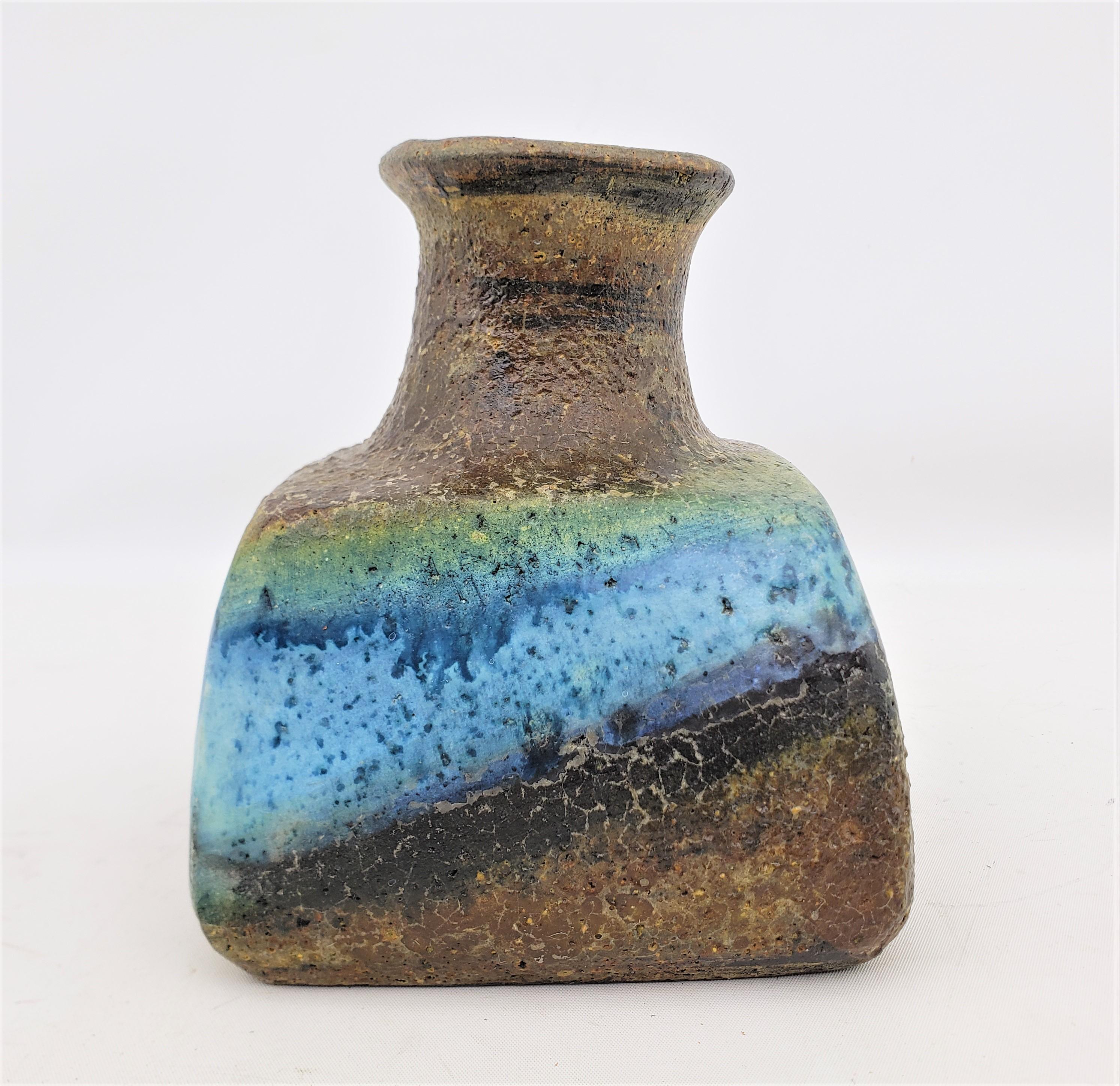 This art pottery vase was done by the renowned Marcello Fantoni of Italy in approximately 1960 in the period Mid-Century Modern style. The vase is done with a thick dark brown clay and has a squared or 'pillow' shaped base with a stout round neck.