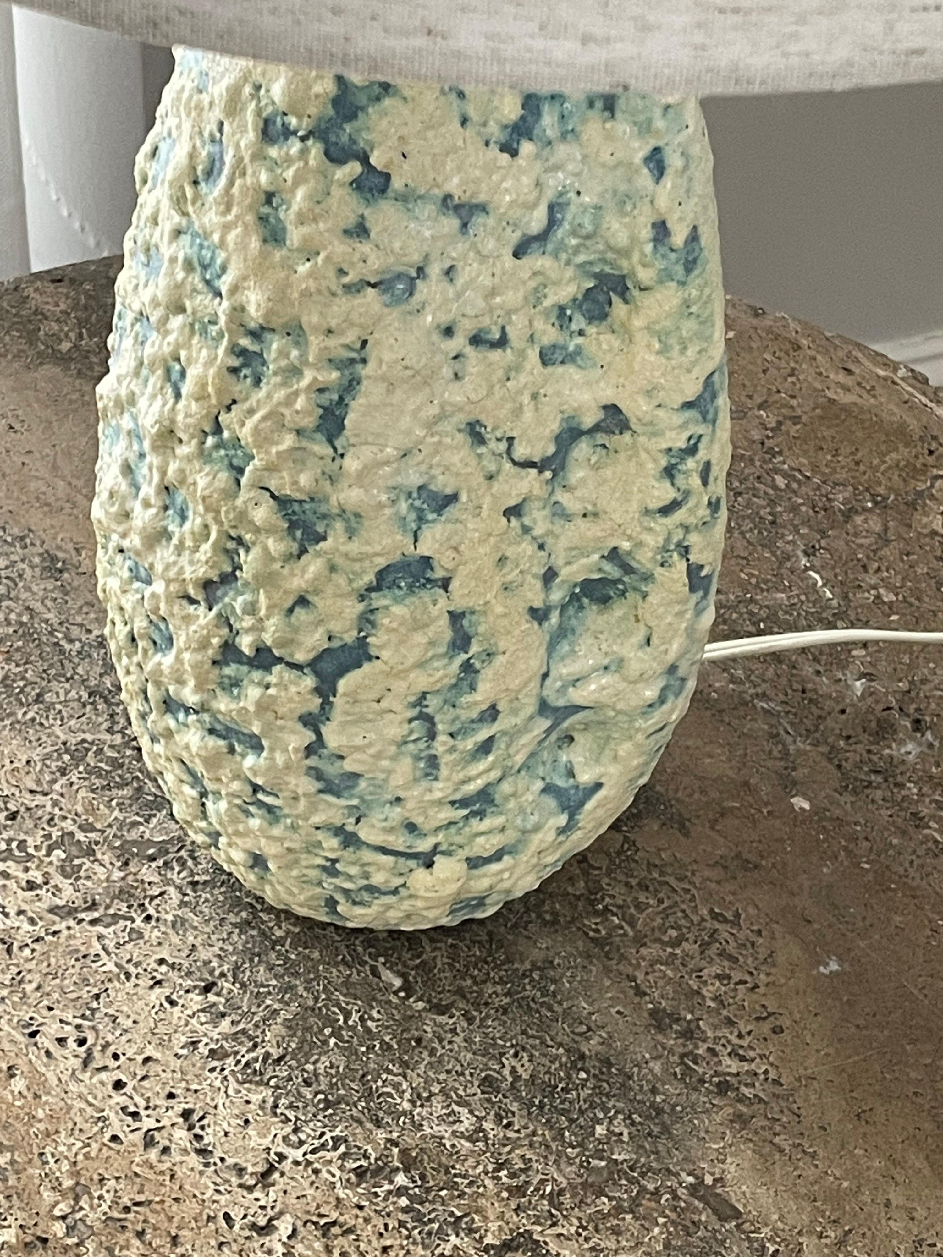 Table lamp by Marcello Fantoni. Heavily textured lava glaze with light blue, light green, and cream colors. 

Overall Dimensions
24” tall
15” wide

Ceramic Portion
13” tall 
6” wide
5.5” deep

Other notable designers from the period include Guido