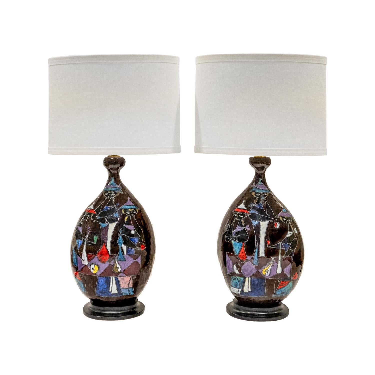 Superb pair of hand-thrown and painted ceramic table lamps, each with a colorful figural motif,  on ebonized wood bases by Marcello Fantoni, Italian 1950's (signed).  These are rare and important works by the artist.  They are absolutely stunning in