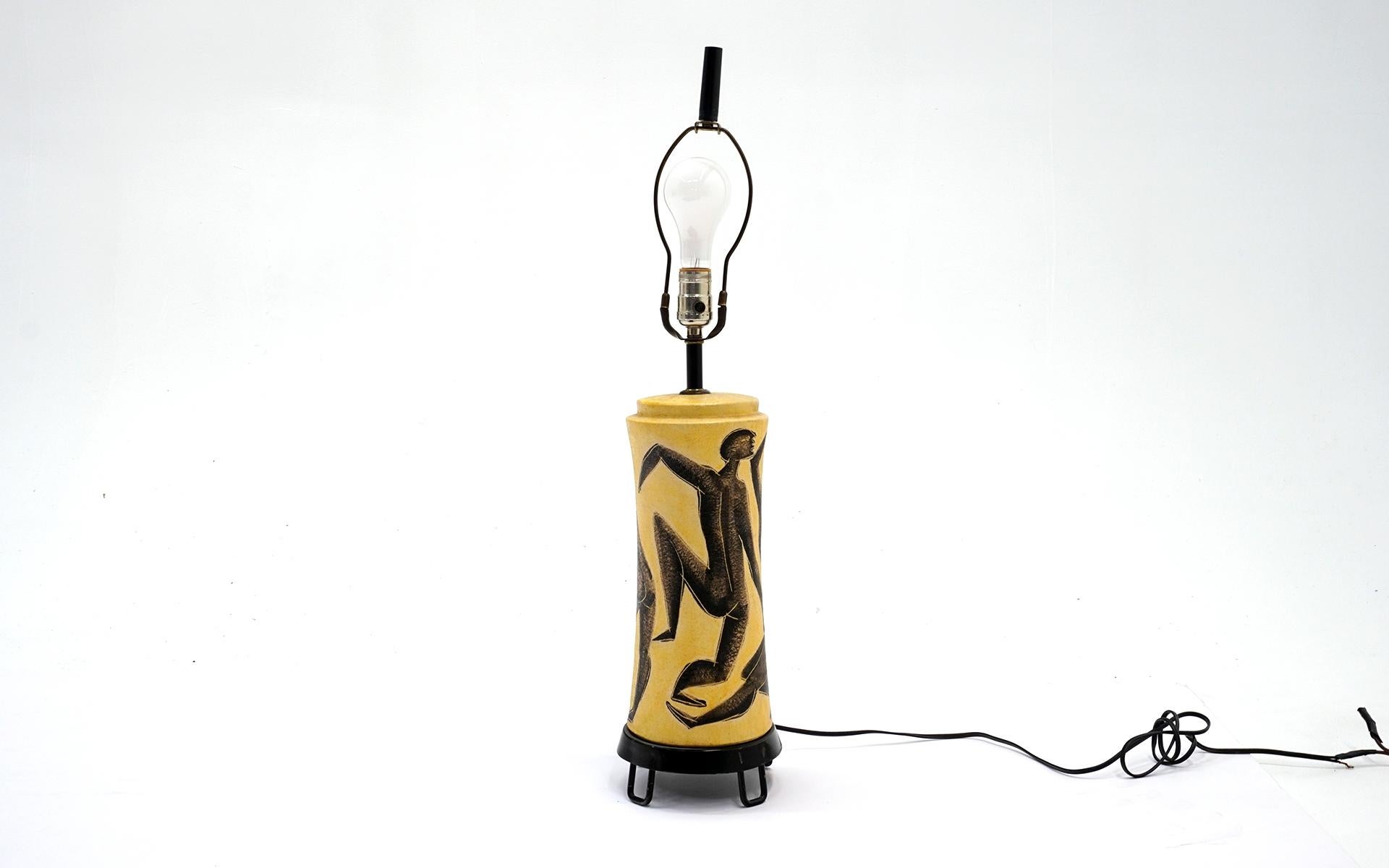 Rare 1950s pottery table lamp by Marcello Fantoni. Includes the shade and the original finial. Hand painted figural forms in charcoal / black on a yellow background. No chips, cracks, or repairs. Some losses to the enamel on the base. The threading
