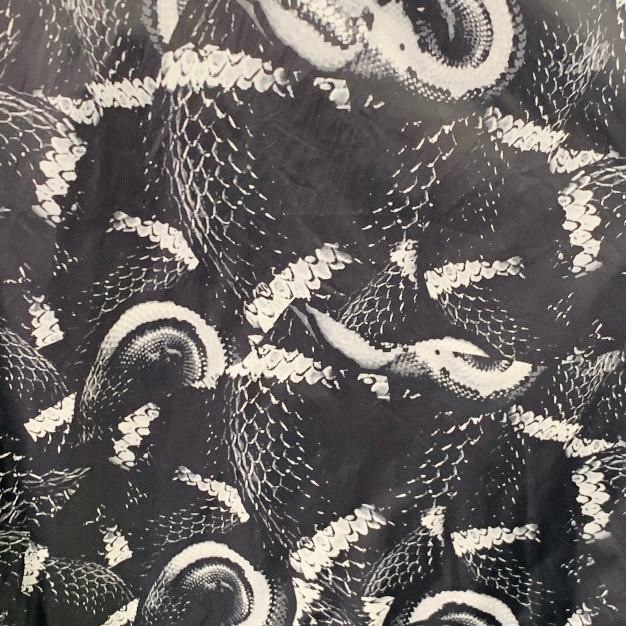 Imperméable MARCELO BURLON
en polyamide noir et gris, avec un motif serpent symétrique, une coupe oversize, un style à capuche et une fermeture à glissière. Excellent état d'origine. 

Marqué :   M 

Mesures : 
 
Épaule : 17.5 pouces Poitrine : 82