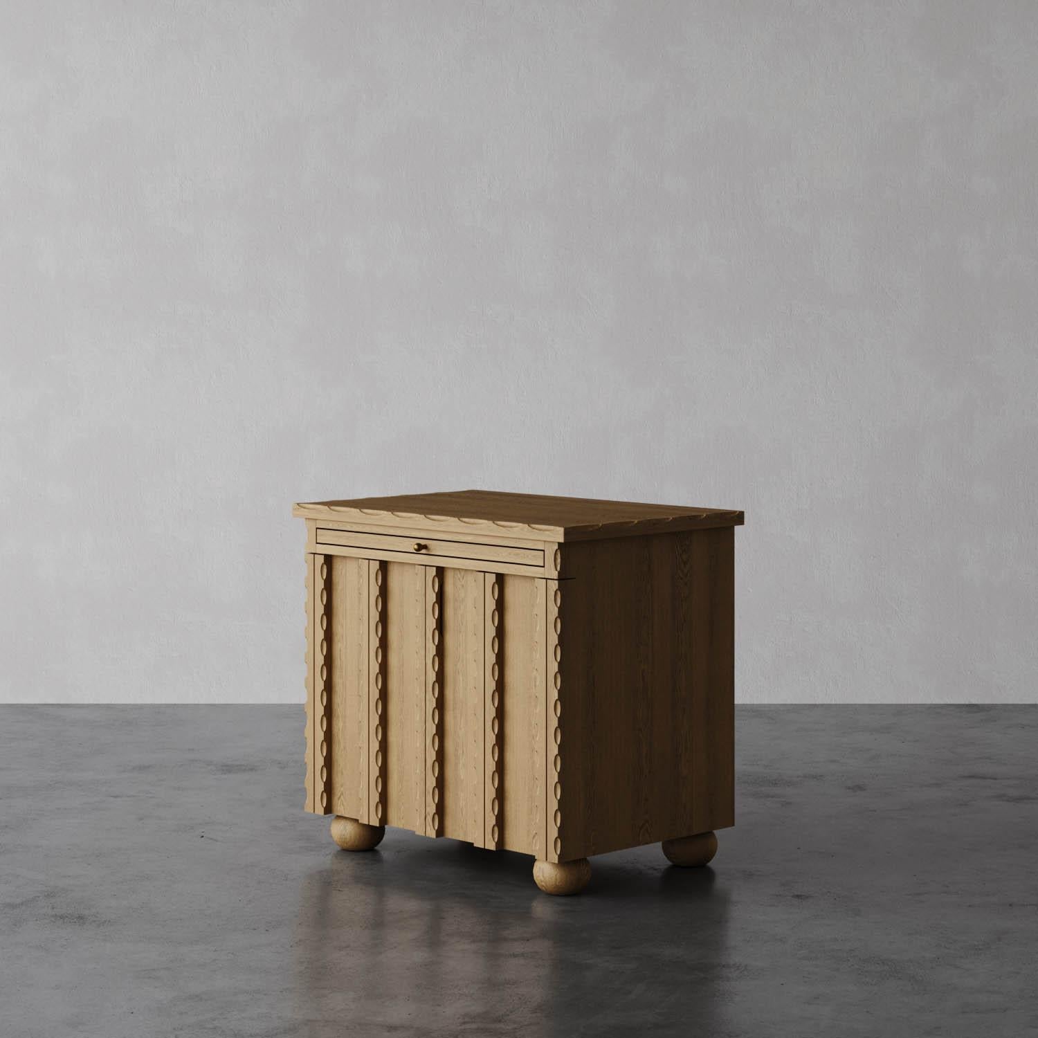 Il comodino Marchand è caratterizzato da un elegante bordo smerlato e da frontali con ante testurizzate, che creano un design di spicco per qualsiasi camera da letto. Progettato per la massima praticità, include un ripiano estraibile per riporre