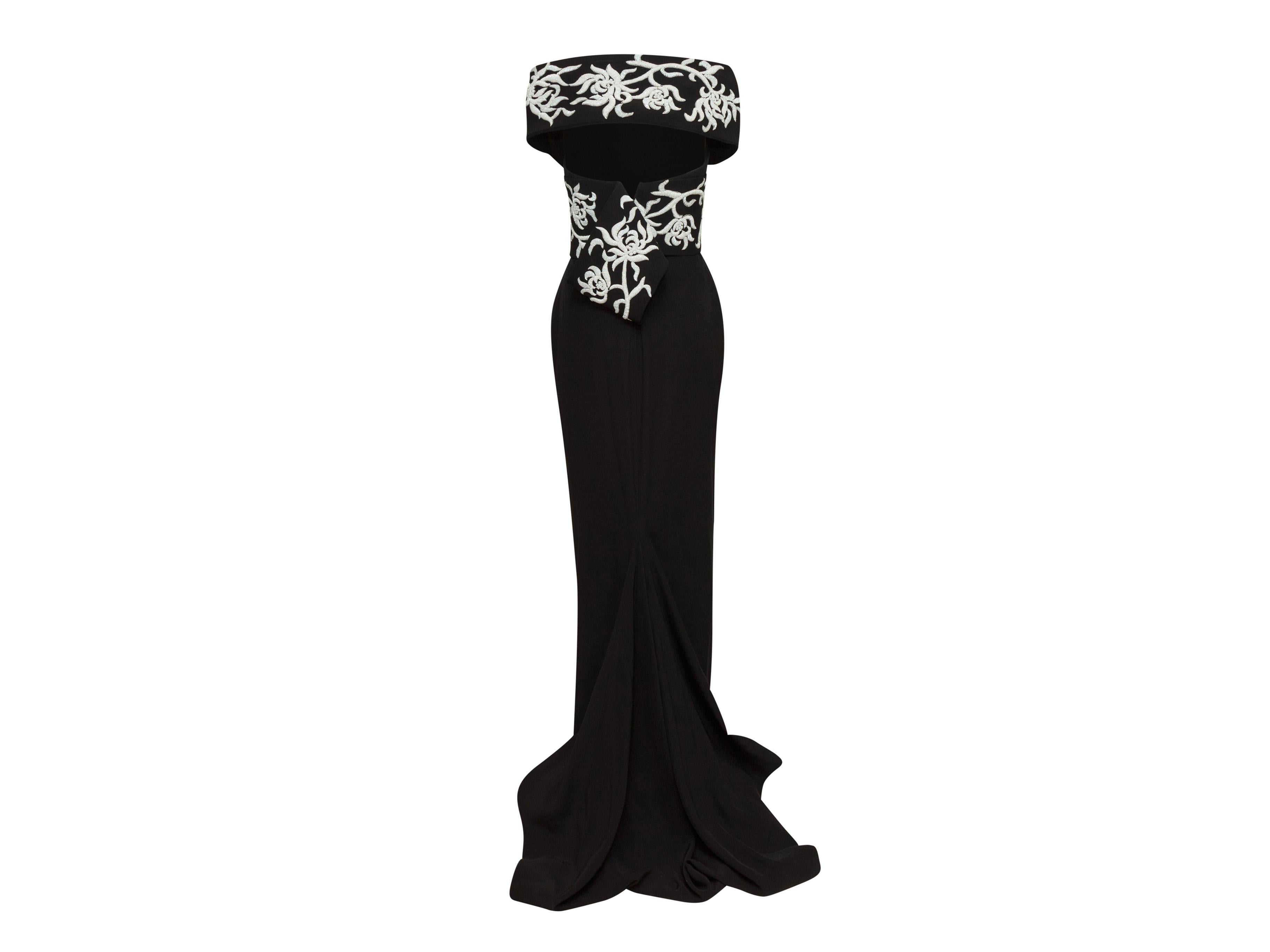 Product details: Black silk gown by Marchesa. White beading throughout bodice. V-neck. Keyhole at back. Zip closure at back. 31