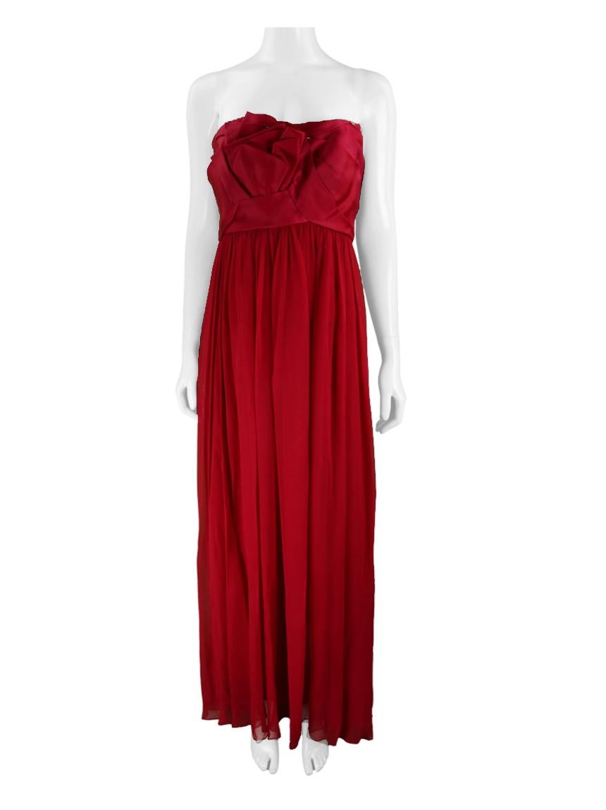 Original Long Red Marchesa Dress made of fabric with overlay on the skirt.
The strapless model has a long length, a fitted silhouette with a flared skirt, a bust with draped details and a back hook and zip fastening. Accompanied by a red tulle