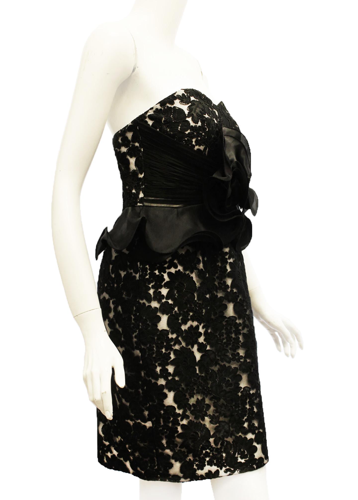 Marchesa Notte black lace strapless dress with white lining giving this cocktail dress a dramatic look. At front, on bodice a flower like ruffle in black continuing with peplum like ruffle at waistline.  Perfect for any special occasion!  The