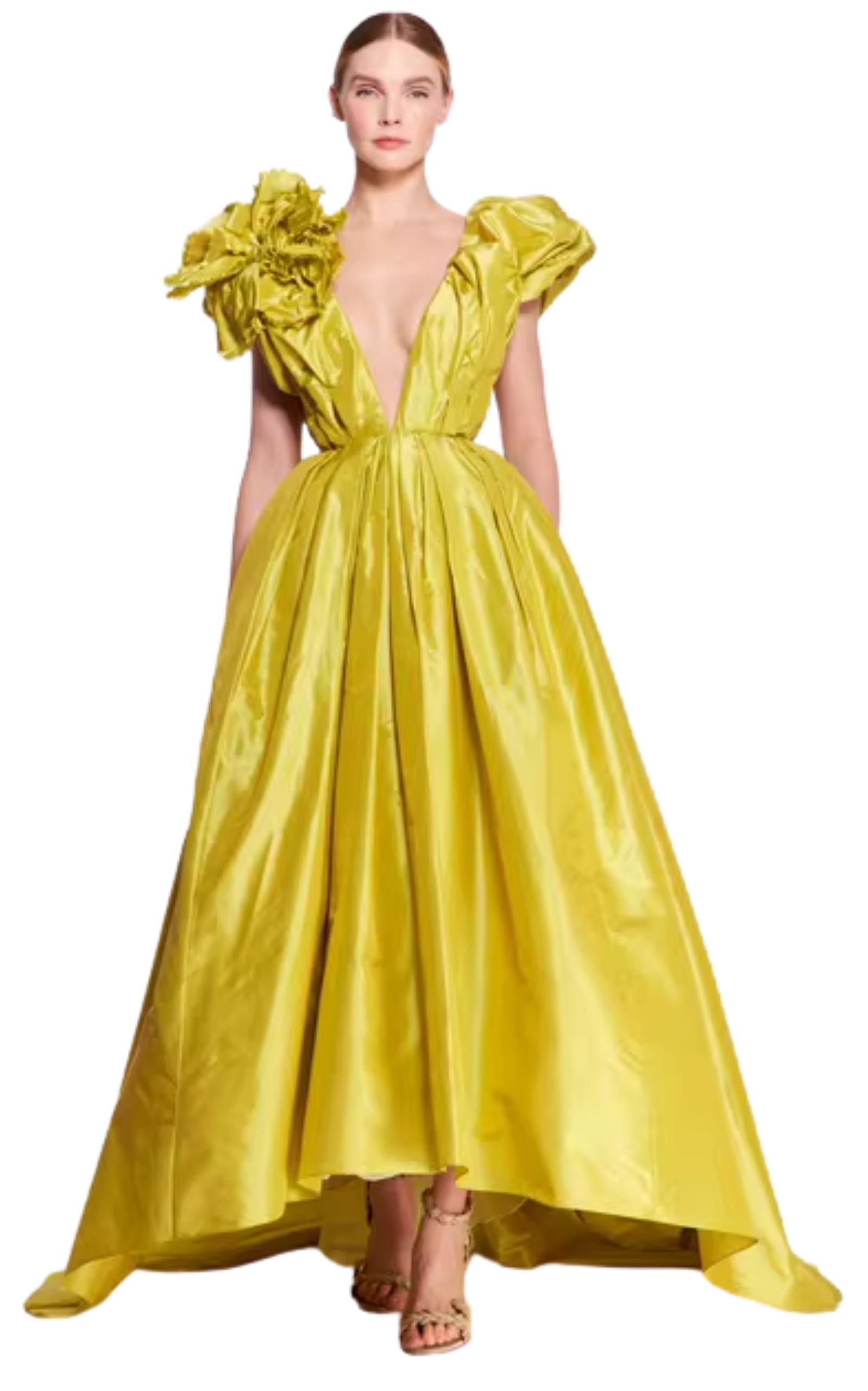 Llamativo sin esfuerzo, este vestido de baile Marchesa Couture de la colección Otoño 2023 es una obra maestra del romanticismo moderno. Confeccionado en tafetán luminoso, el vestido presenta un amplio escote pronunciado, mangas abullonadas