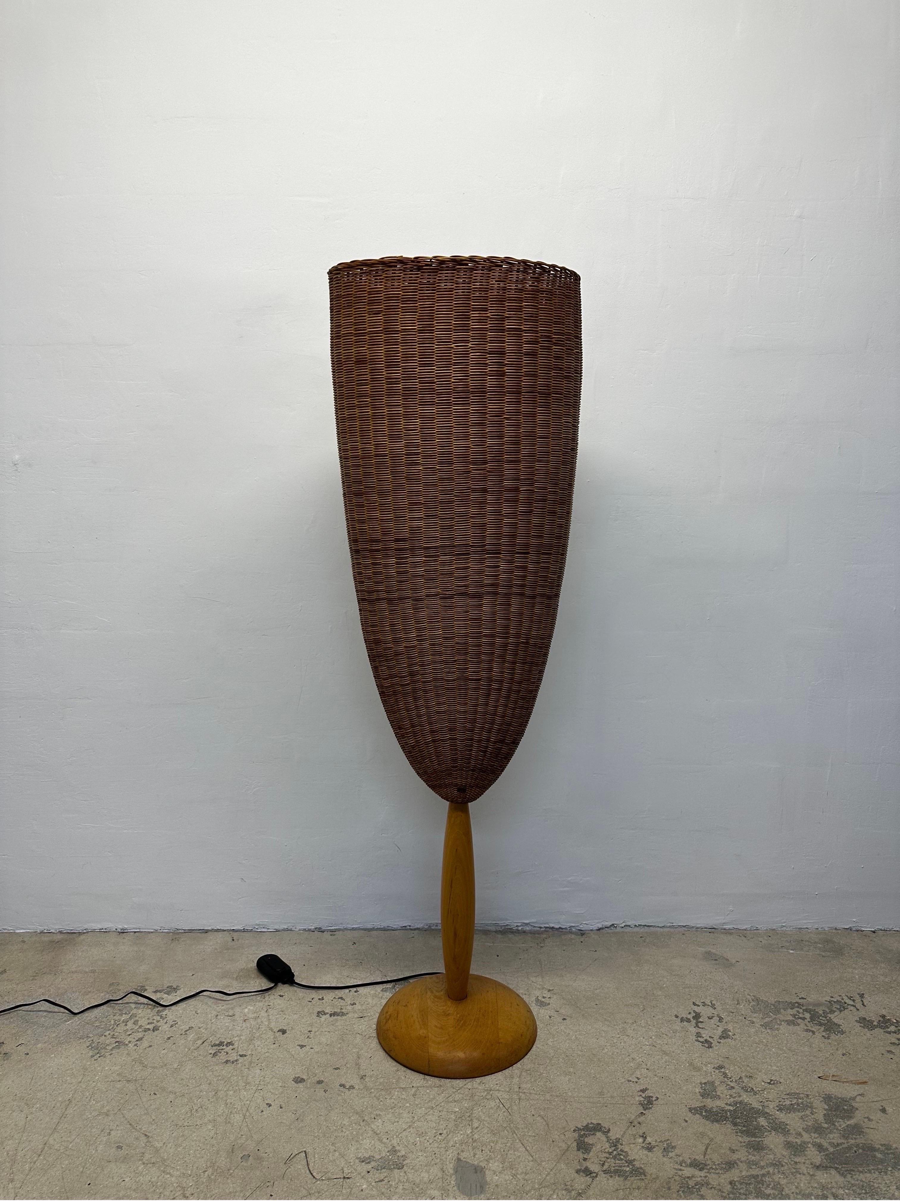 Organic modern Flûte floor lamp with large woven cane lamp shade that sits upon a beech wood carved base designed by Marco Agnoli for Pierantonio Bonacina, Italy 1991.