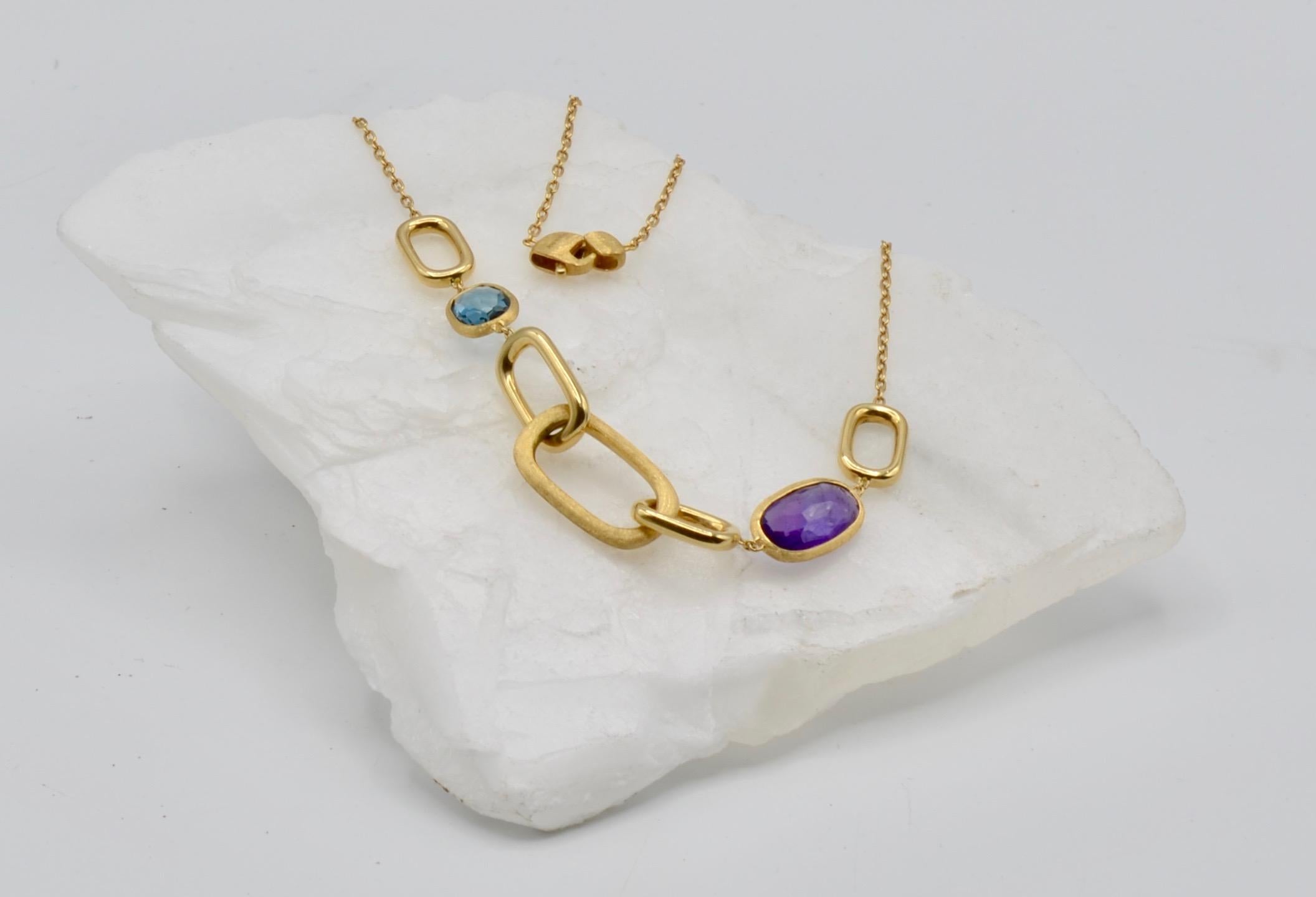 This elegant link is a signature of the designer Marco Bicego. The 18 karat brushed yellow gold is a perfect compliment to the amethyst and blue topaz faceted stones embedded in the link design. This is a perfect everyday necklace to wear alone or