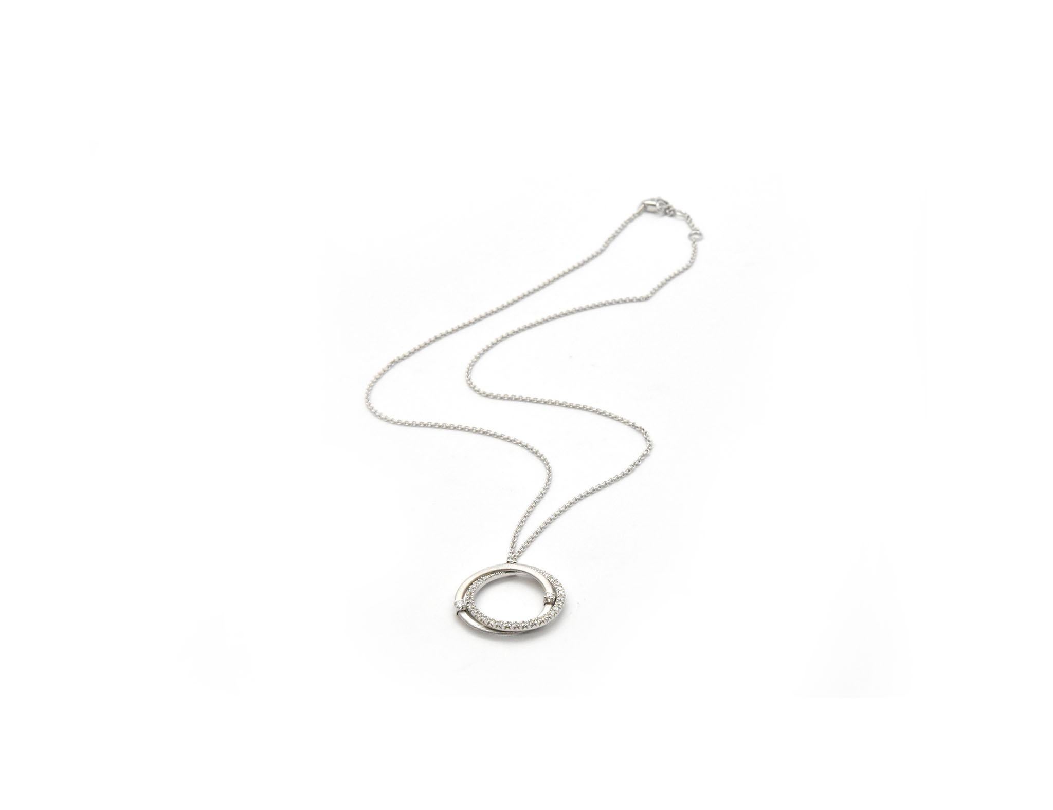 This necklace is designed in 18k white gold by Marco Bicego. The triple ring pendant is set with diamonds for a total weight of 0.51ct. The pendant measures 23mm wide, and it sits stationary on a 16-inch chain. The necklace weighs 7.71 grams. It is