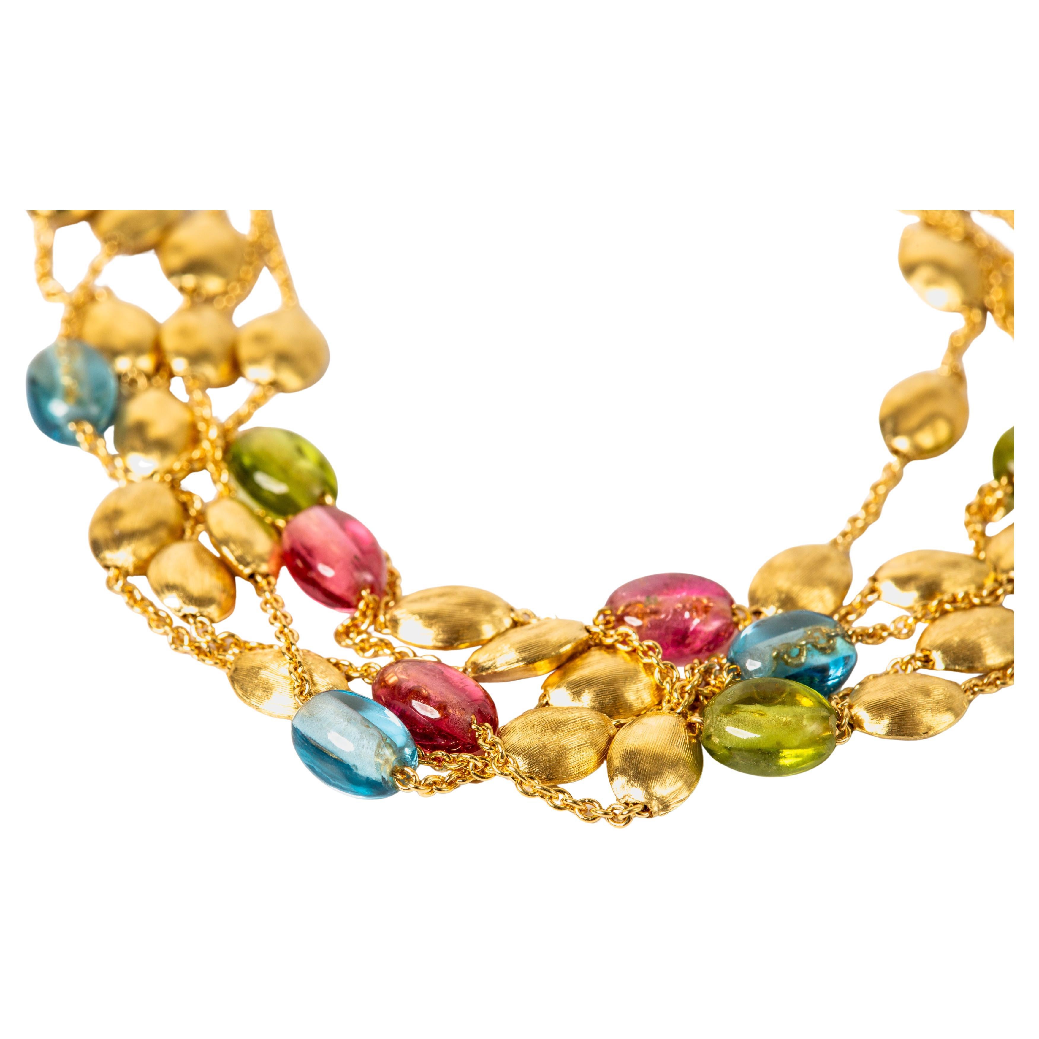 Material: 18k Yellow Gold
Gemstones: Pink Tourmaline, Peridot, Topaz
Weight: 17.1 grams
Length: 8 3/8 inches
Designer: Marco Bicego

This beautiful 5 strand bracelet adorned with colorful gemstones is a piece of jewelry that blends elegance and