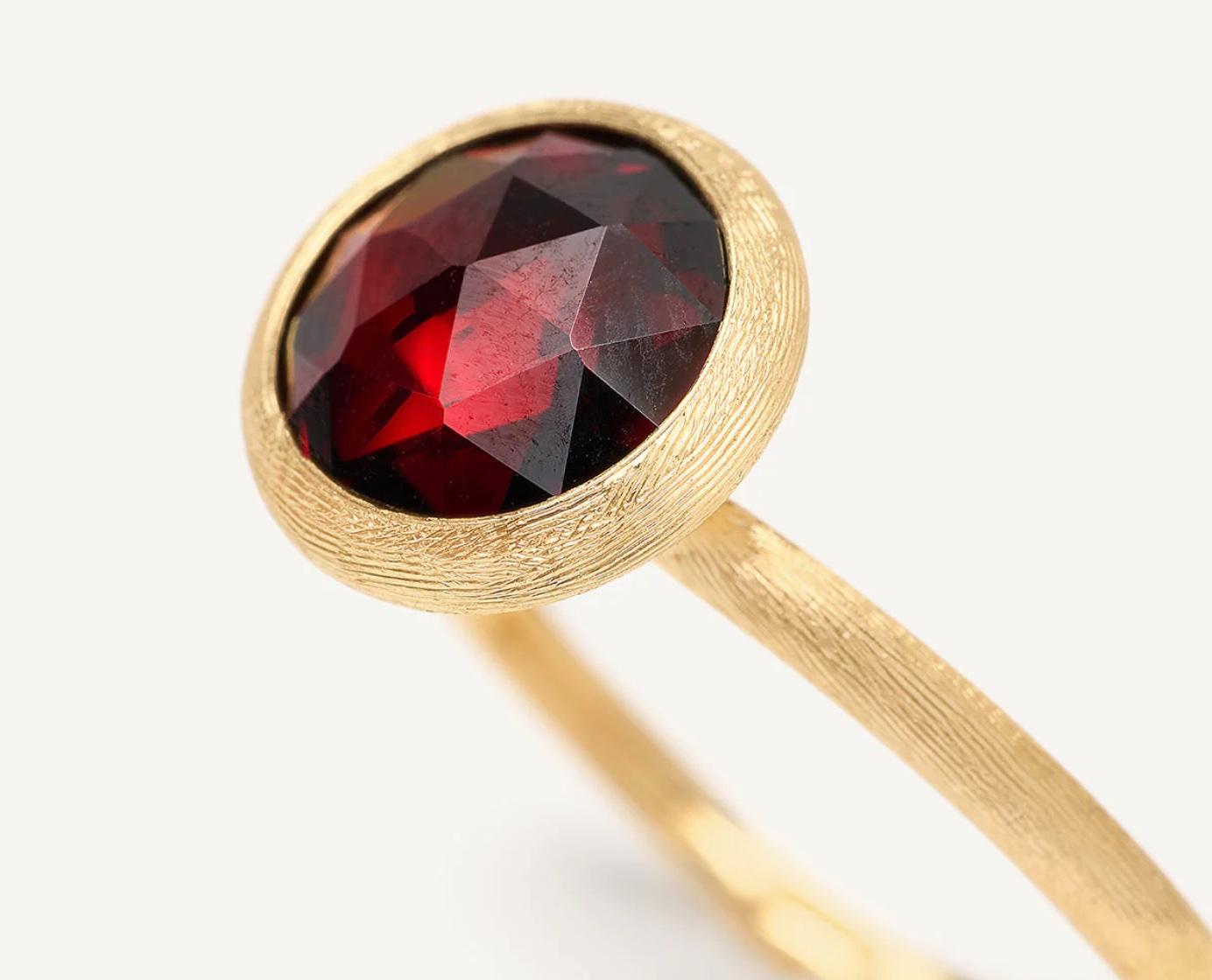Questo splendido anello del designer italiano Marco Bicego, appartenente alla Collection'S, contiene un granato rotondo taglio rosa di circa 6,00 mm di diametro, elegantemente incastonato in un anello inciso a mano con finitura Florentine antica.