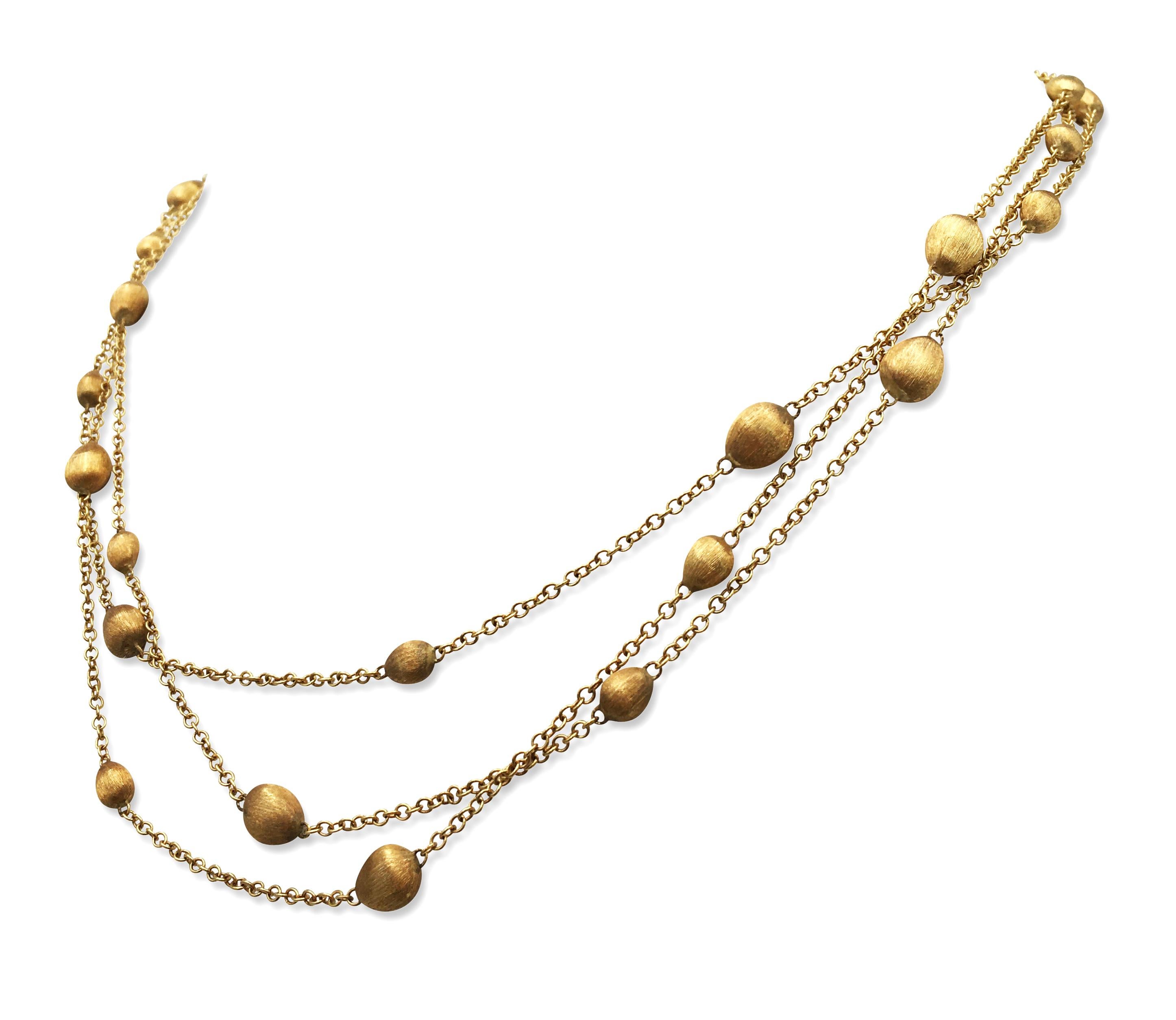 A multi-strand gold necklace featuring hand engraved gold satin finished pebble stations, made in Itlay by Marco Bicego. The necklace is completed with satin finish lobster clasp. Marked Marco Bicego, '750', Made in Italy. The necklace does not come
