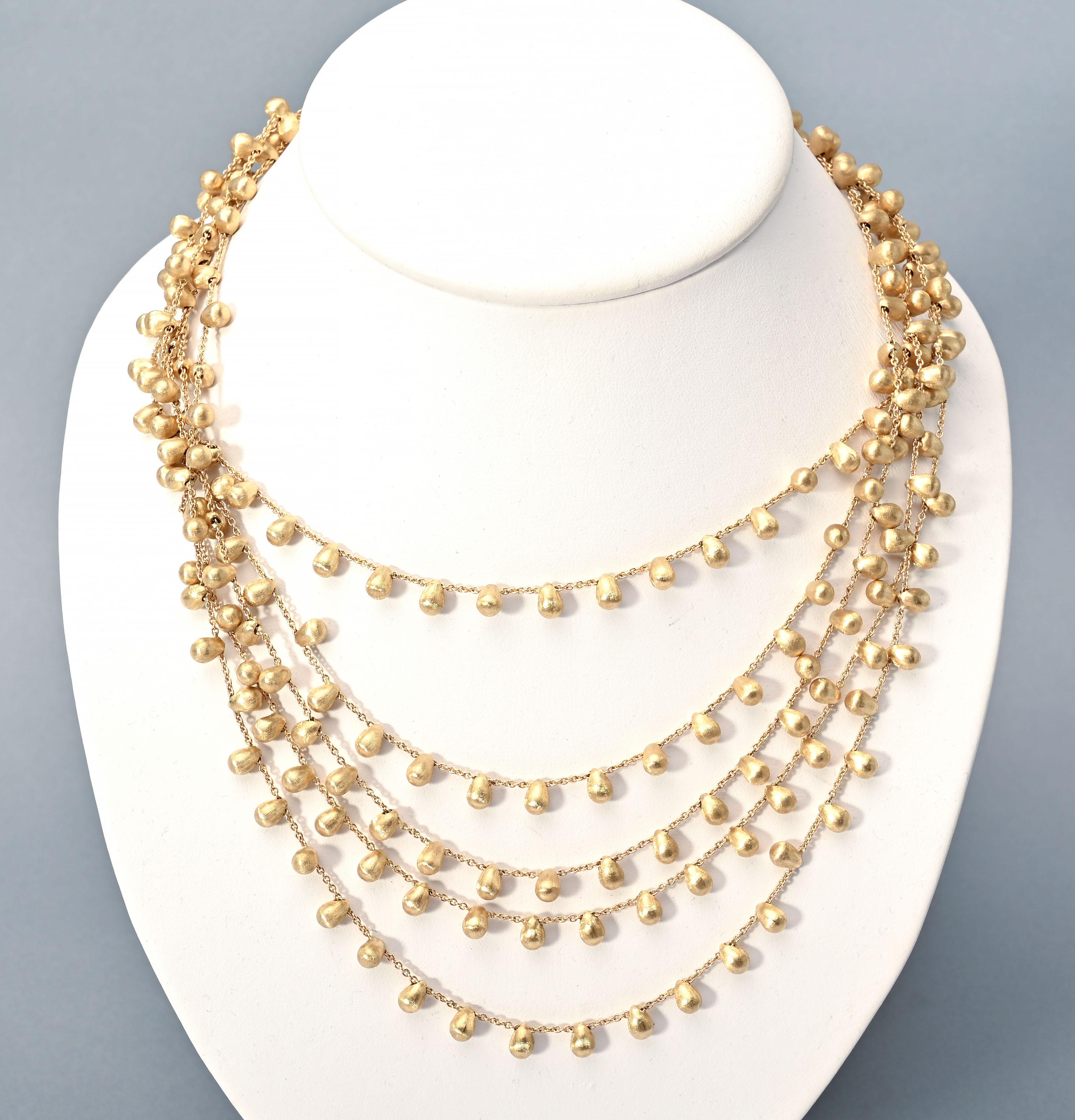 This five strand gold bead necklace is by Marco Bicego, the most popular  of contemporary designers. He  is known for the delicately textured hand etched surfaces he creates to the gold. His pieces are all crafted by hand. This necklace has five