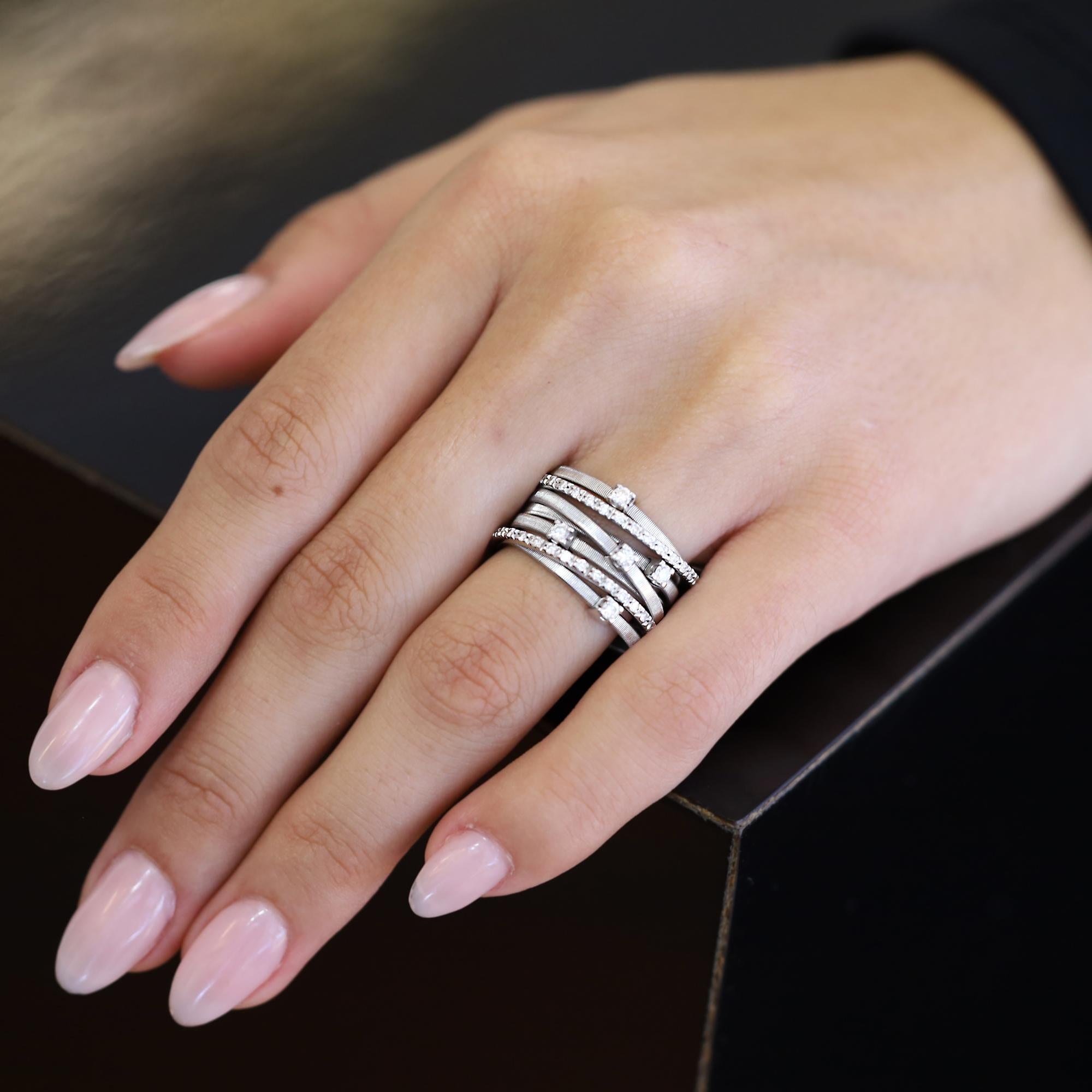 Dieser atemberaubende Ring aus 18 Karat Weißgold mit breitem Band ist ein wahrhaft ikonisches Schmuckstück. Er ist ein Zusammenspiel aus flachen Spiralfäden, die sorgfältig mit der exklusiven Spulentechnik hergestellt wurden, und mit Brillanten