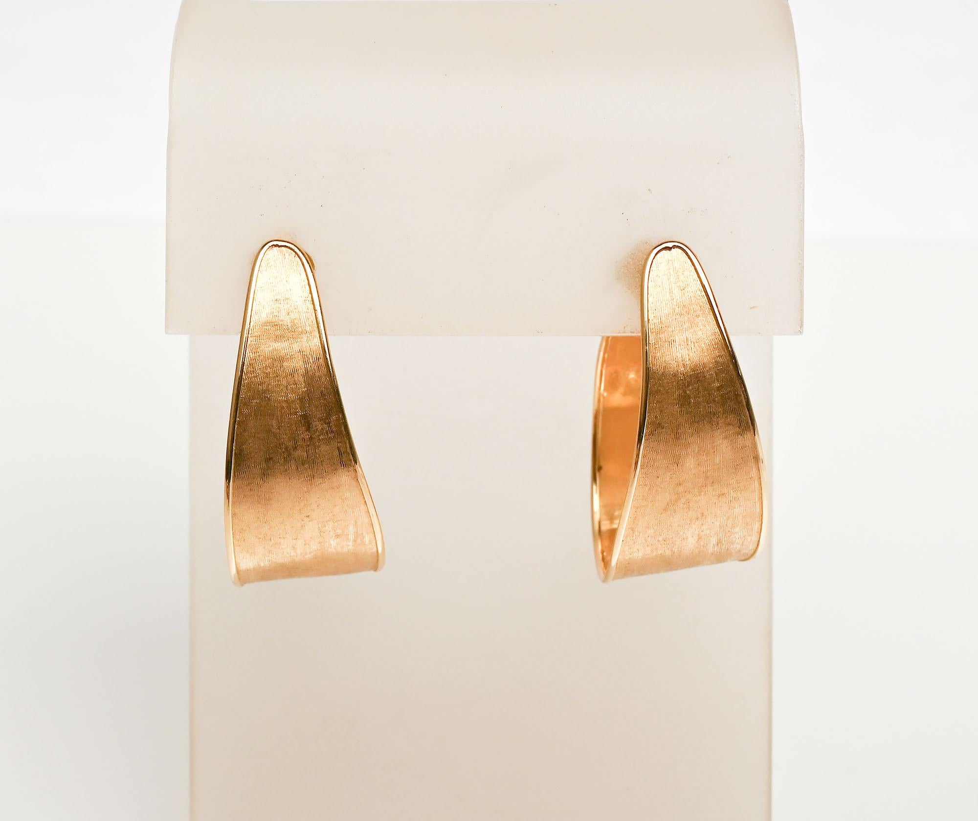 Elongated hoop earrings by popular designer, Marco Bicego. The earrings have a lightly brushed finish with gloss outlines all around. The earrings are for pierced ears. They measure 1 1/2 inches long and half an inch at the widest. Their light
