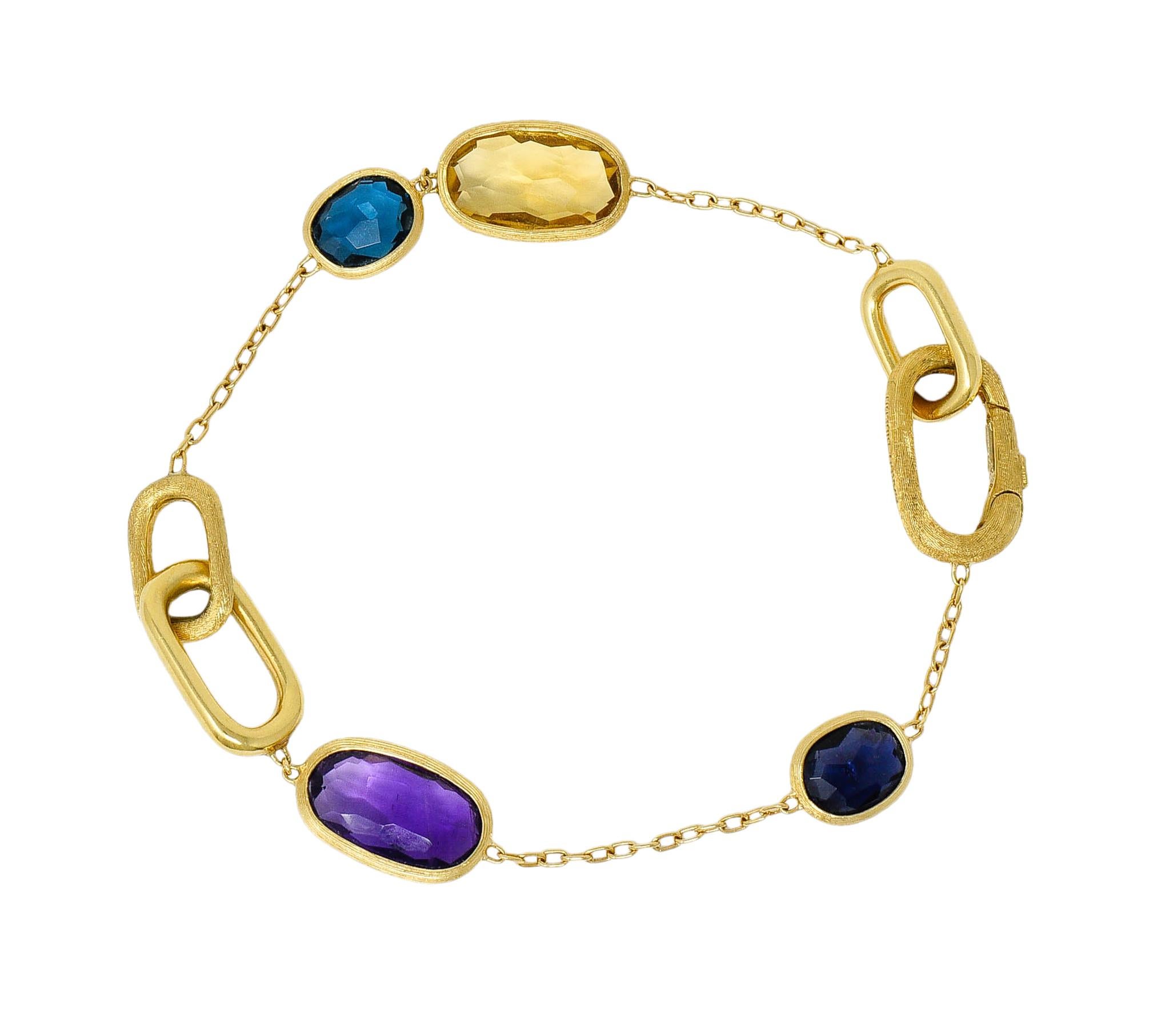 Stylized cable chain bracelet features faceted mixed cushion cut gemstone stations

Blue topaz, iolite, citrine, and amethyst; all bezel set in strongly brushed gold

Accented by oversized cushion style links with a strongly brushed finish and a