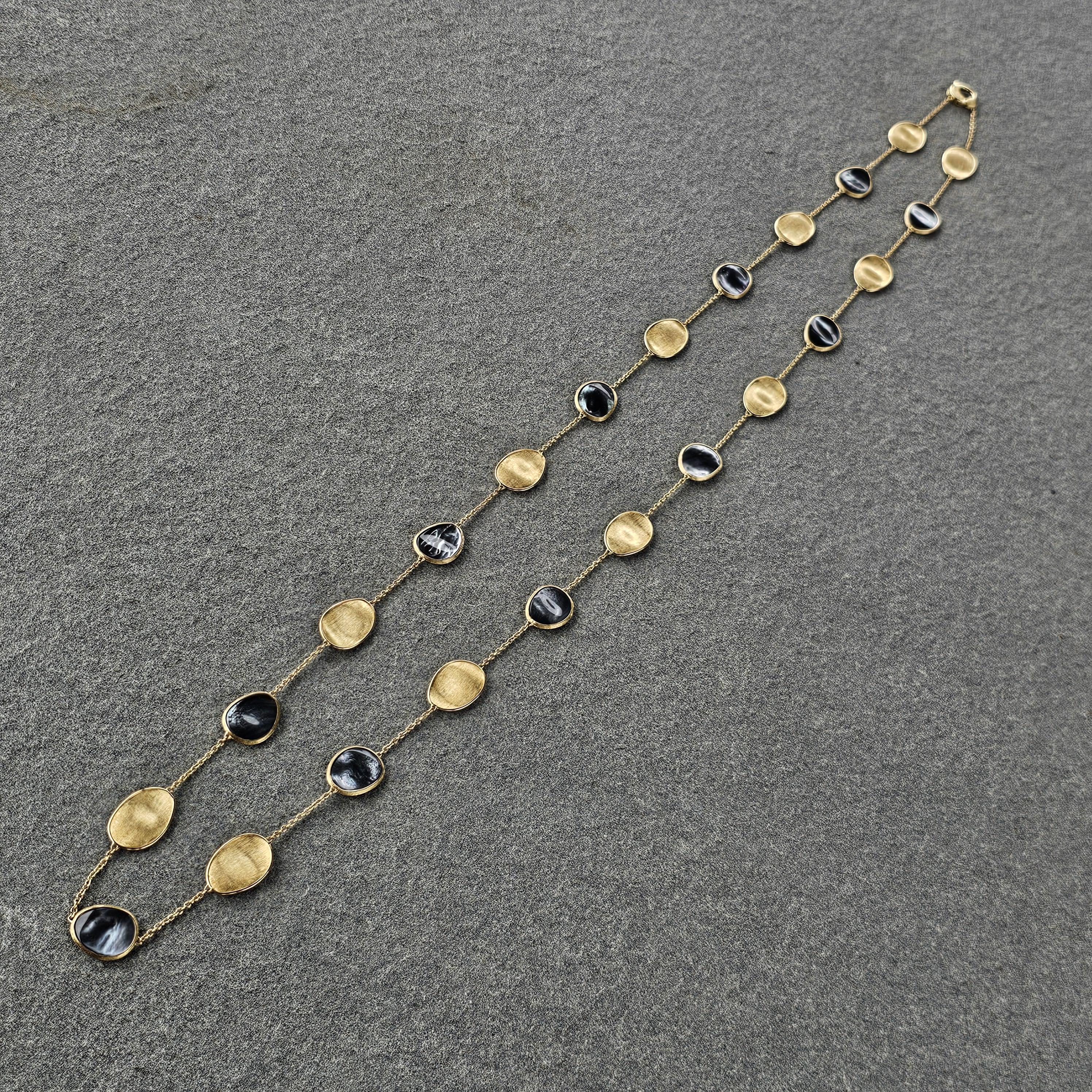 This Marco Bicego chain necklace is a striking addition to any jewelry collection. Crafted from high-quality 18k yellow gold, this piece showcases a harmonious blend of elegance and modern design. The necklace features alternating links of smooth