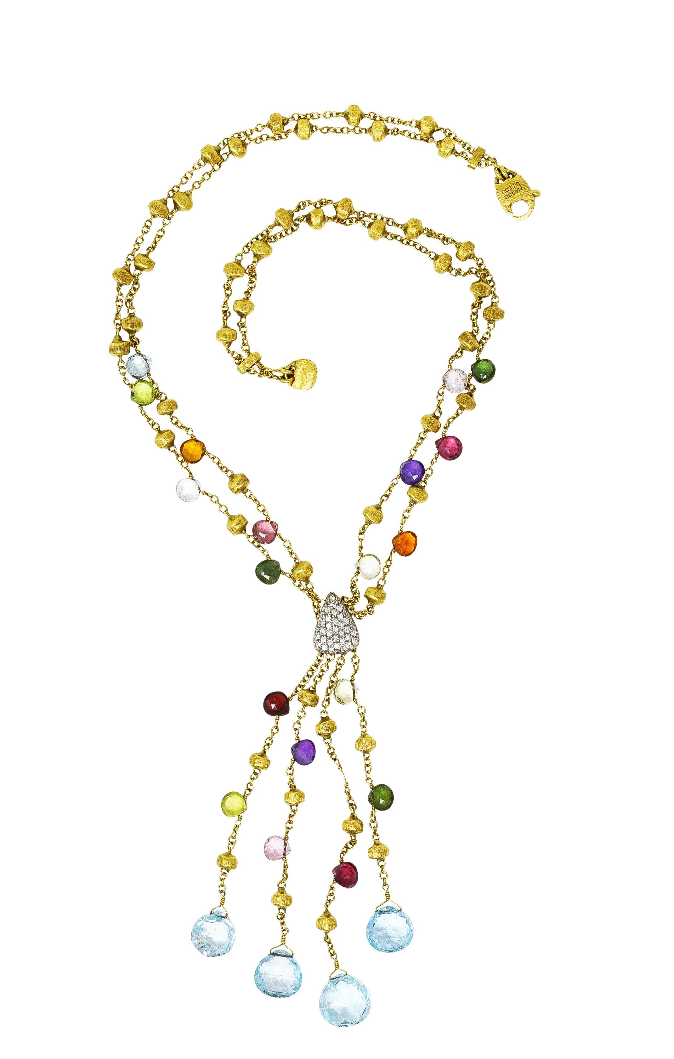 Designed as lariate style necklace of four cable chain strands suspending fringe with blue topaz drops. Cable chain strands are beaded throughout with brushed gold and multi-gem beads. Gemstones are pink tourmaline, green tourmaline, blue topaz,