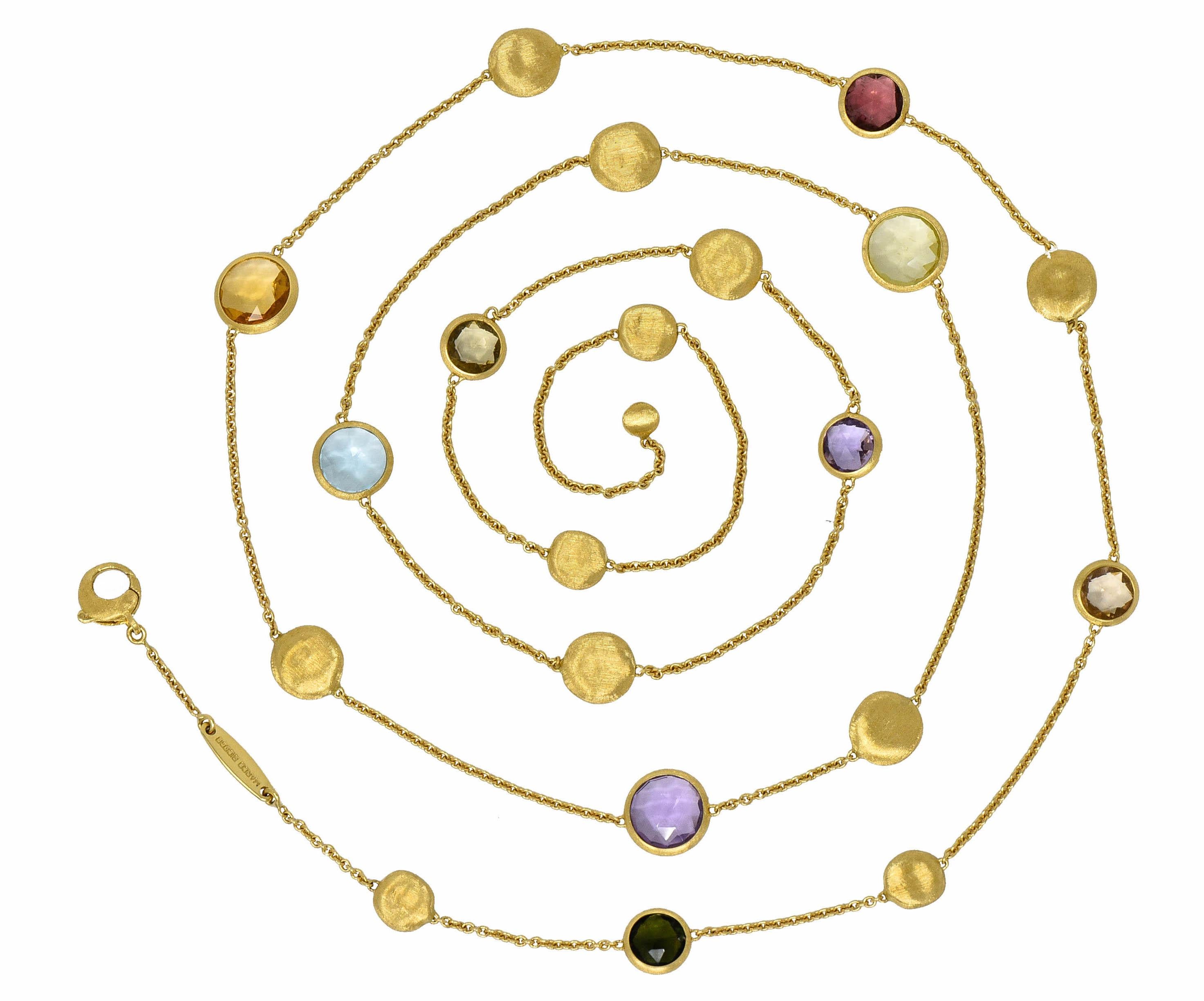 Necklace is designed with brushed gold oval stations alternating with gemstones, bezel set in brushed gold surrounds

Featuring round cut and faceted tourmaline, topaz, peridot, beryl, and others

Completed by cable chain terminating as a stylized