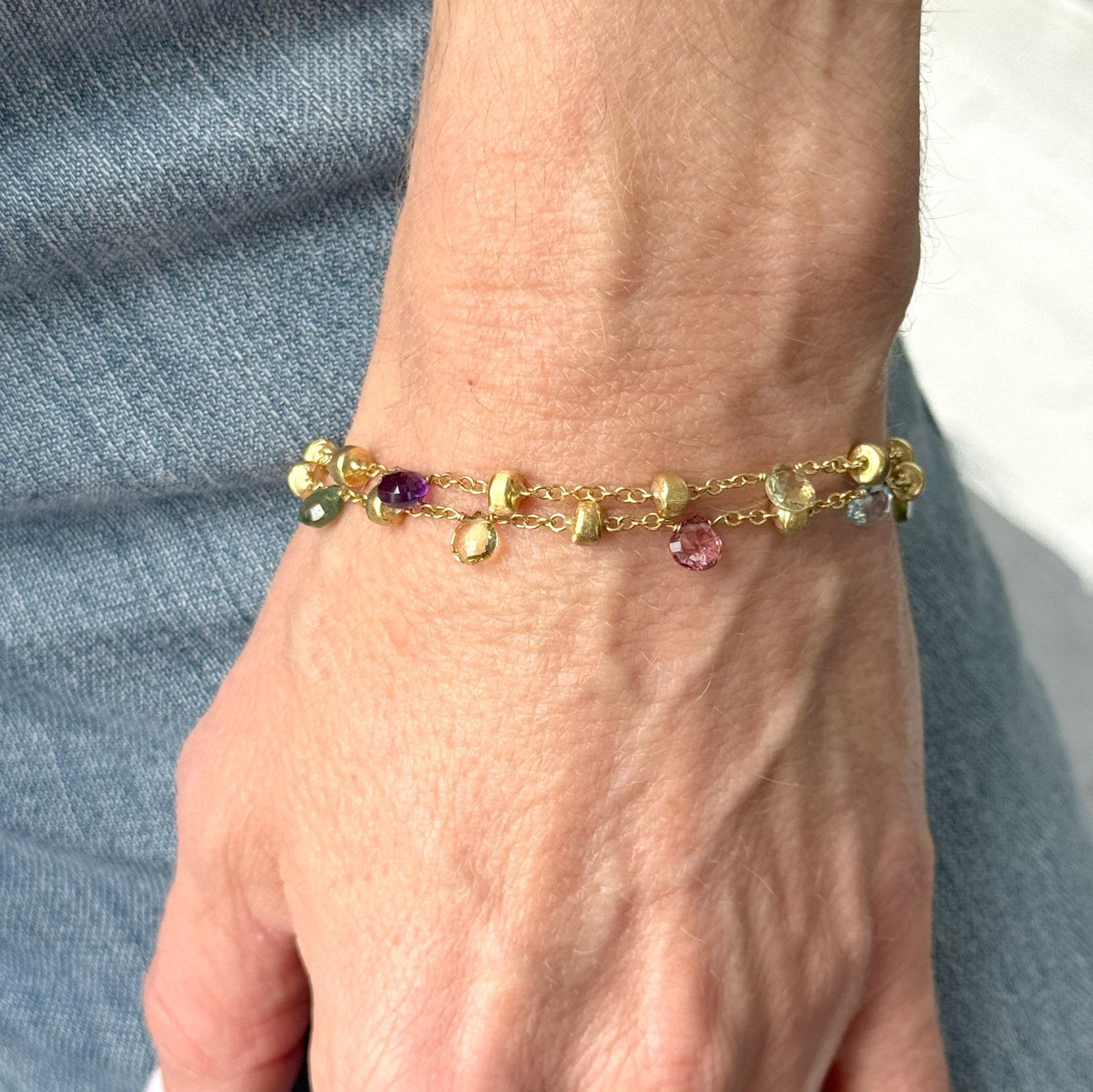 Ce magnifique bracelet multibrins Marco Bicego Paradise se distingue par ses combinaisons de couleurs vibrantes, les pierres précieuses multicolores côtoyant des topazes ciel d'une élégante pureté. Les pépites en or jaune 18 carats sont finement
