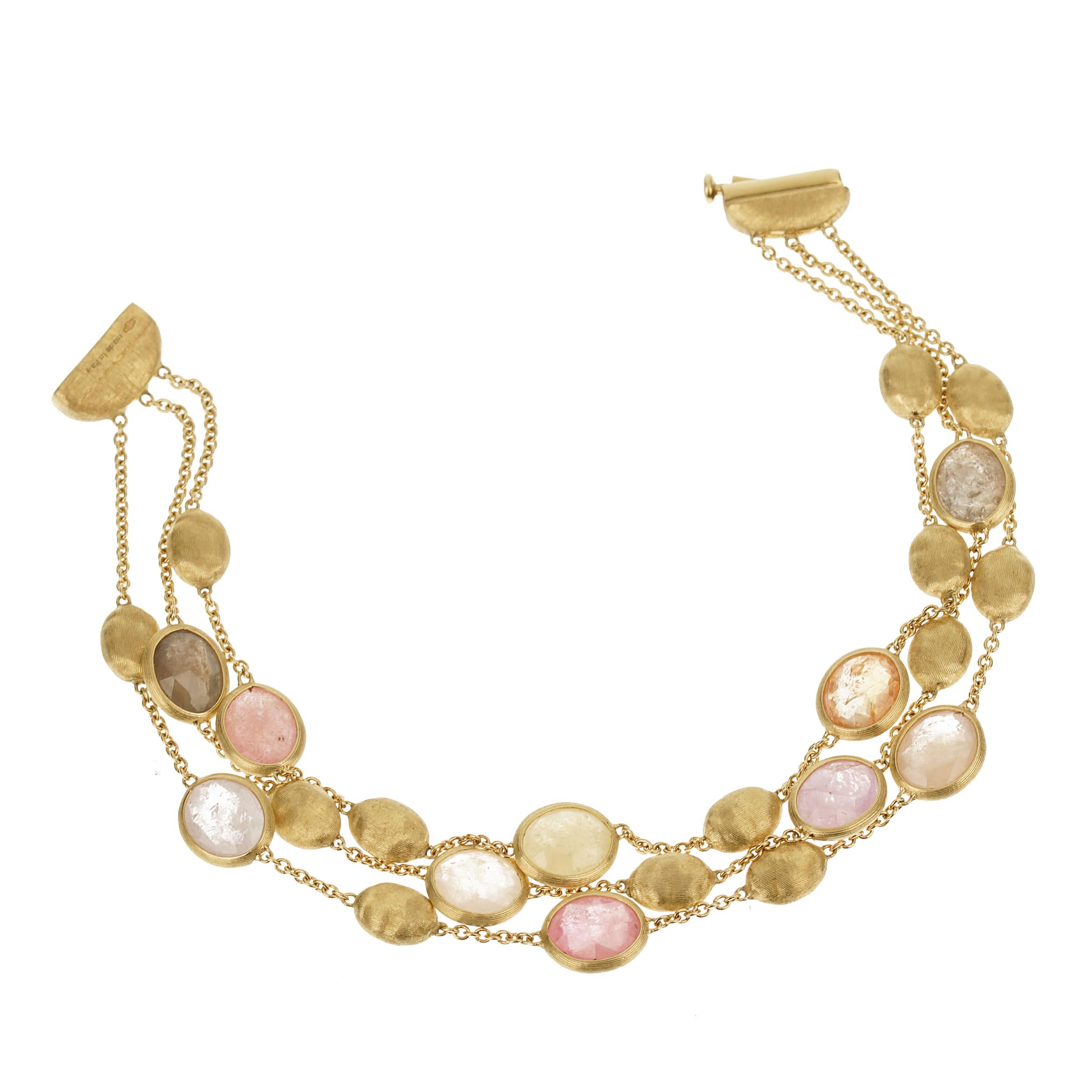 The Marco Bicego Siviglia Gemstone Yellow Gold Bracelet is an embodiment of luxurious elegance and artisanal craftsmanship. This exquisite piece features three rows of alternating vibrant gemstones and hand-engraved pebbles, meticulously crafted in