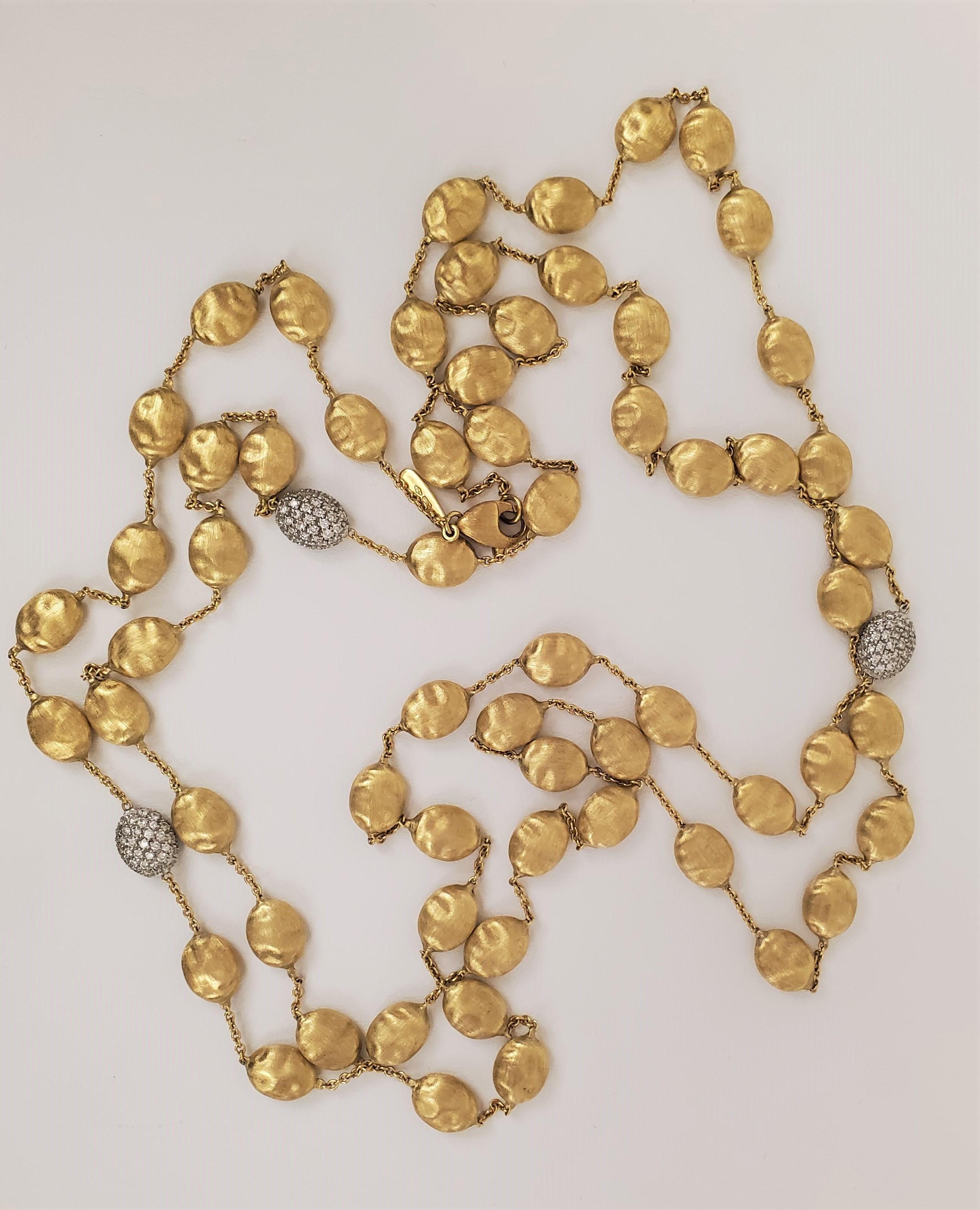 Inspired by the ancient Sevillian cobblestone streets, Marco Bicego's Siviglia 49.5 inch long necklace features 18 karat yellow gold pebbles with an elegant hand-engraved finish. Three pebbles are pave set with an estimated 0.90 carats of diamonds