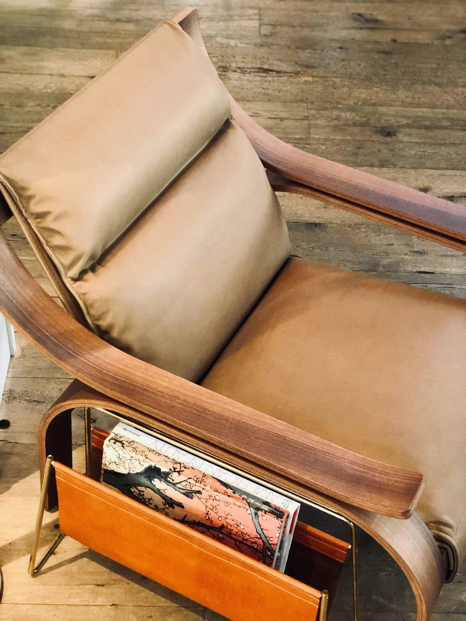 The 722 Woodline armchair, originally designed by Marco Zanuso in 1964, is composed of three distinct elements: curved wood frame, supporting panel and cushions. The wooden frame is made of curved plywood with walnut stained walnut finishes. The