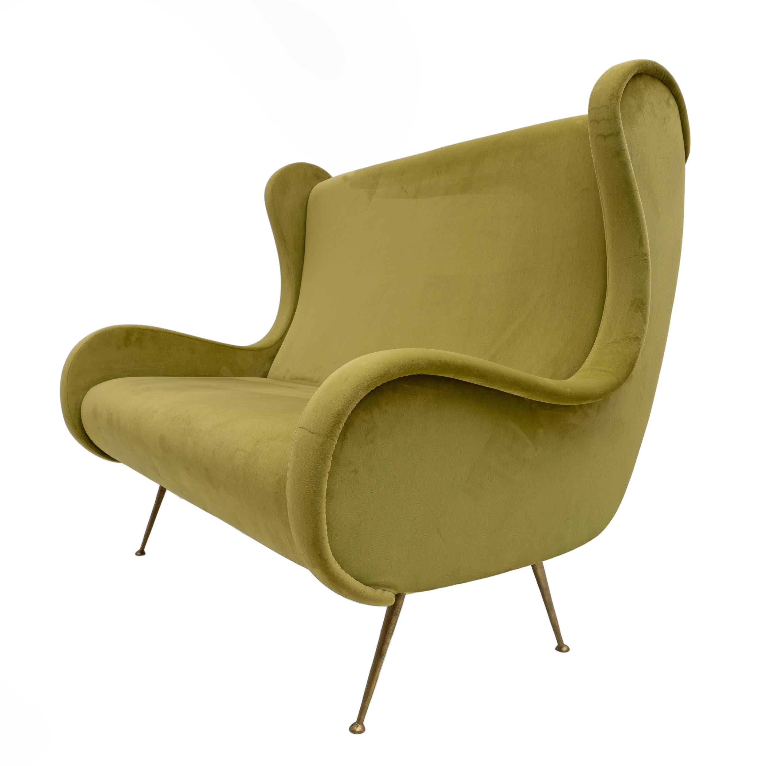 Divano Senior a 2 posti degli anni '50, il divano è caratterizzato da una struttura affusolata con piedi in ottone. Il divano è stato completamente restaurato qualche tempo fa, con rivestimento in velluto verde chiaro, il velluto presenta piccoli