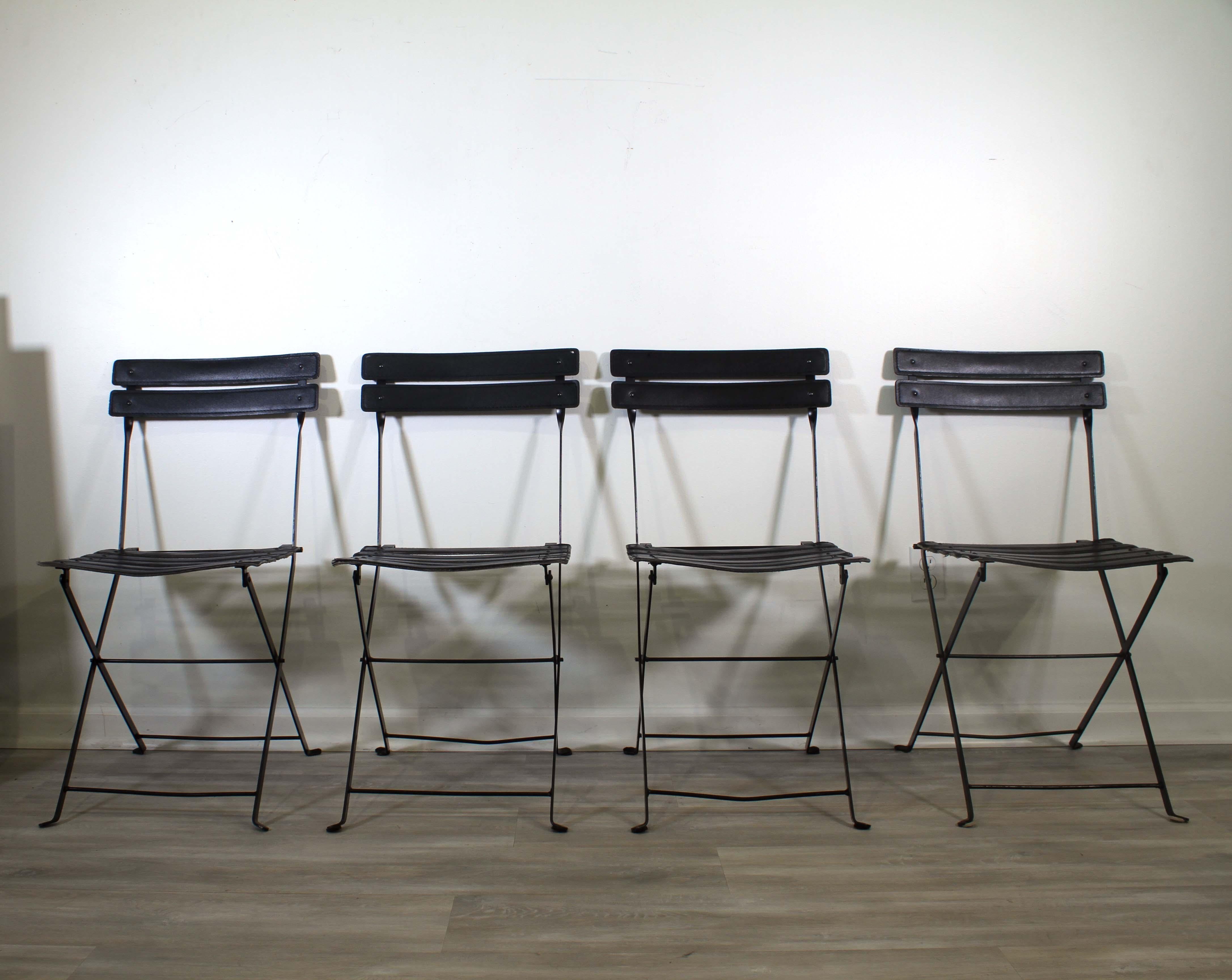 An iconic set of 4 folding chairs with a black steel frame with black leather banding by Marco Zanuso for Zanotta Celestina. Italy 1970s. A fantastic modern interpretation of the folding chair that is sophisticated and stylish. From a private