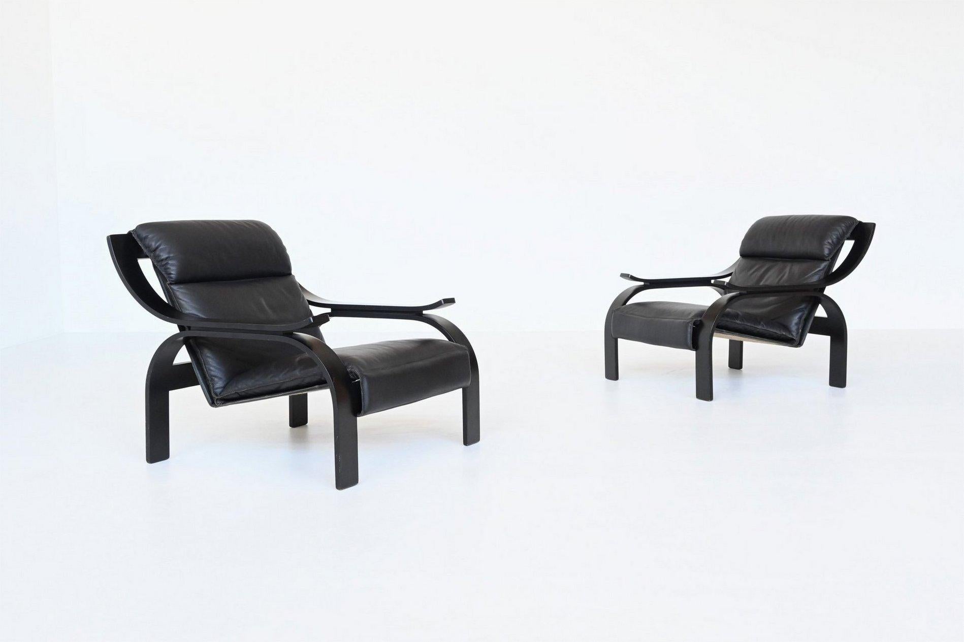 Iconic pair of Woodline lounge chairs designed by Marco Zanuso for Arflex, Italy 1964. These fantastic shaped chairs feature a black lacquered plywood frame and the seat is covered with high quality black leather. The hanging seat construction is