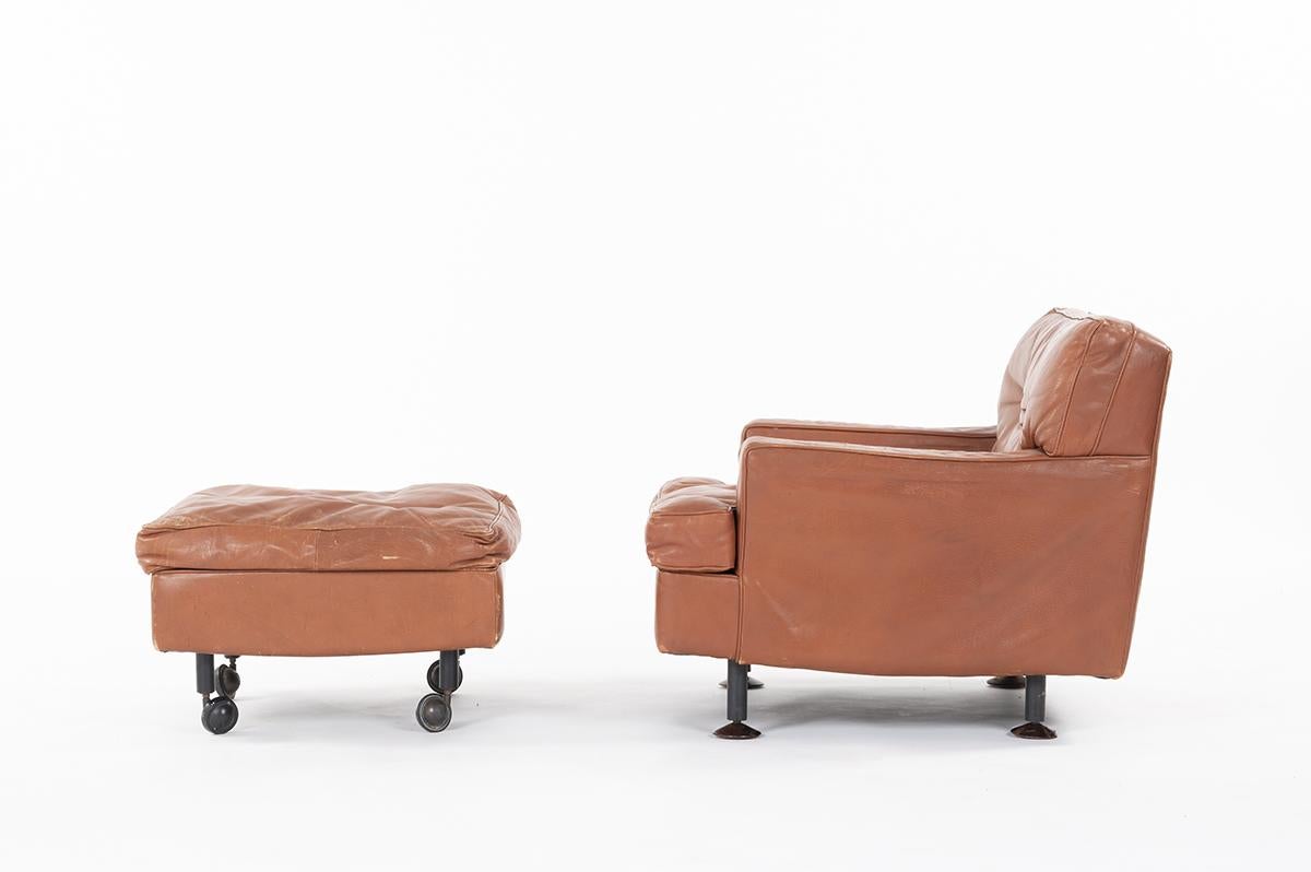 Italian armchair / lounge chair and footstool by the famous Marco Zanuso. Original leather, beautiful patina. 
Fixed wooden legs and footstool has brass wheels.
 