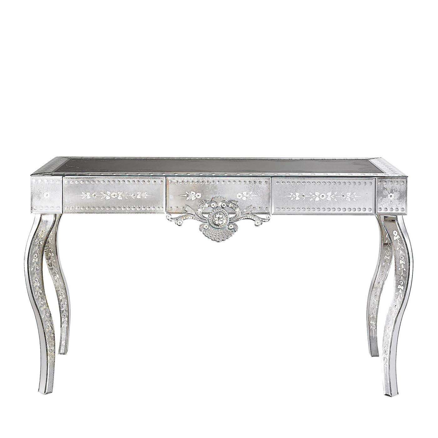 The Marcuola Venetian-style console is part of the San Clemente Collection. Structure made of wood with silver leafed finish. Four flared legs. Top made of black leather with white embroidered details and wavy effect. Front, sides and legs made of