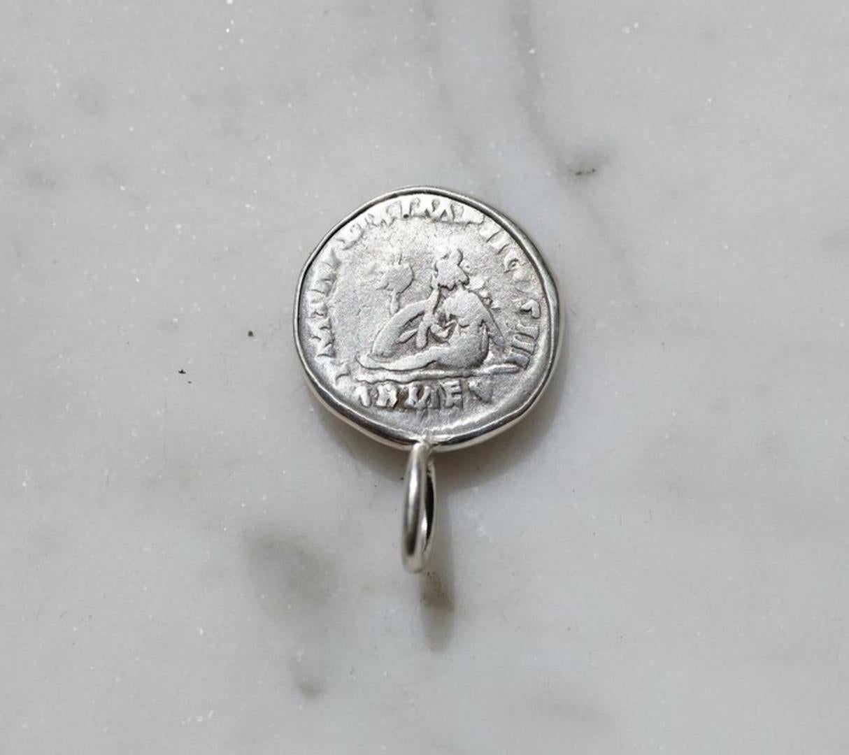 To appreciate the pendant's size, the relief of the coin and the shape of the bail, see the picture showing the coin next to a US quarter. The coin was first set in a gold bezel, which was then hammered over the edge of both sides. This was then