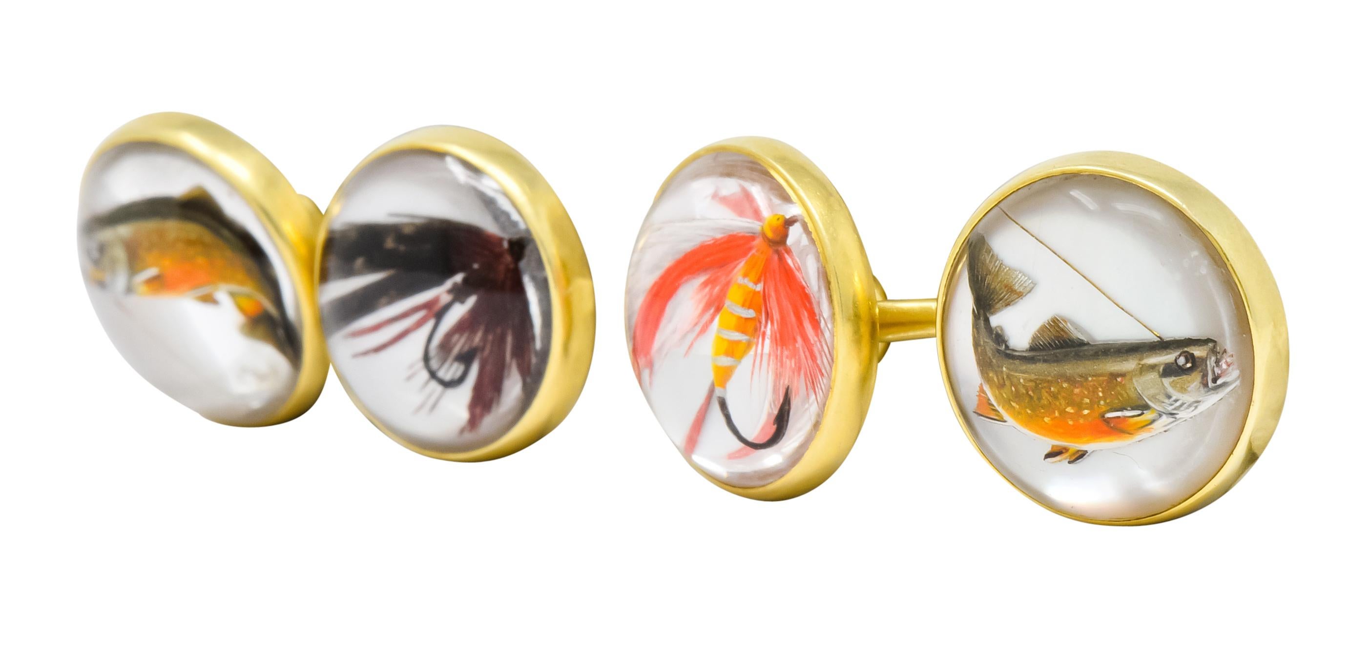 Link style cufflinks featuring a round, transparent rock crystal cabochon measuring approximately 13 mm, bezel set, in a high polished gold surround
With a reverse carved, hand-painted, colorful depiction of fish and feathered fly fishing