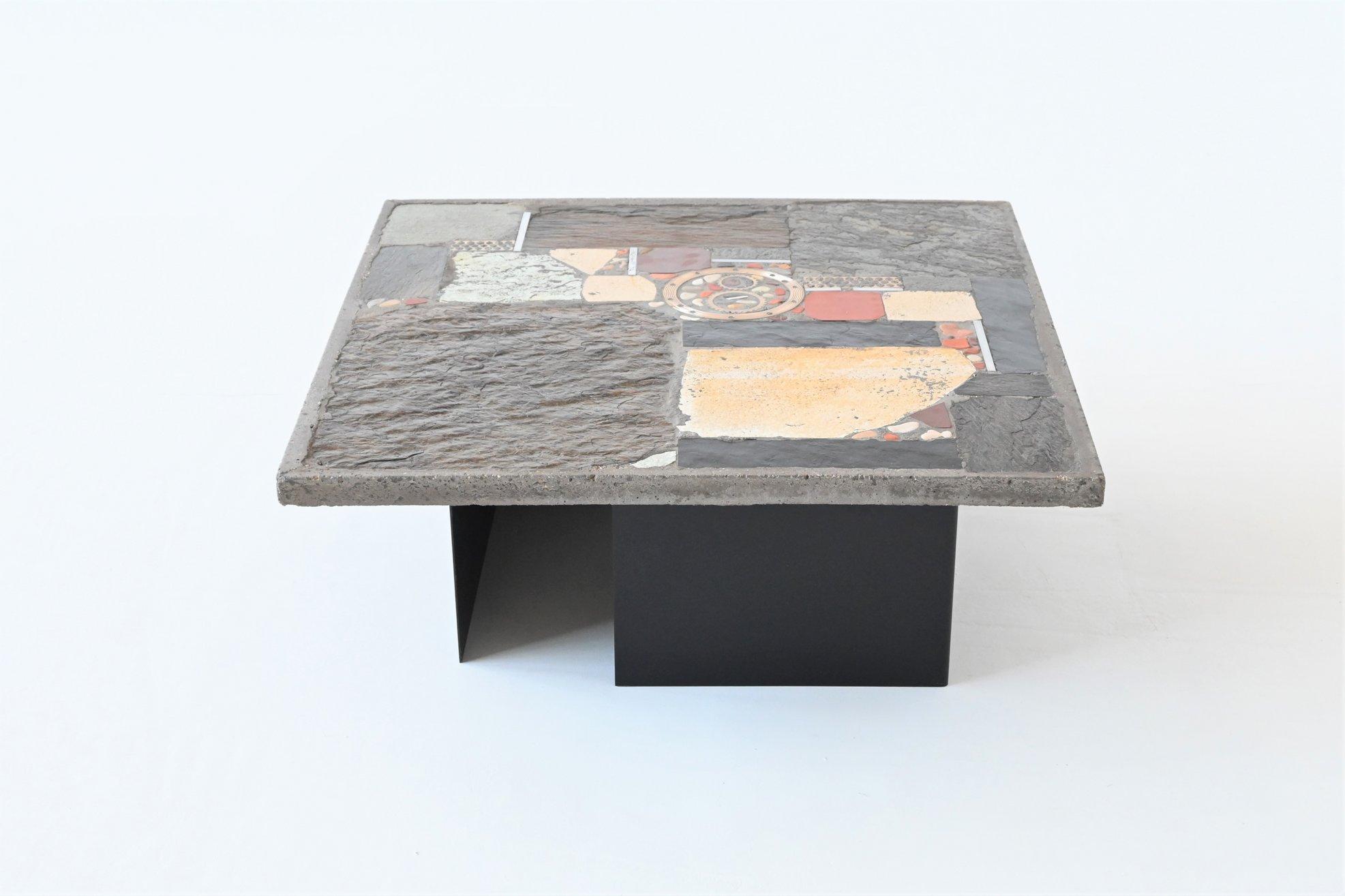 Beautiful square shaped coffee table designed and made by Marcus Kingma, The Netherlands 1974. The grey colored heavy and thick concrete top rests on two metal bases that are black lacquered. Beautiful composition of slate, stones, copper, brass and