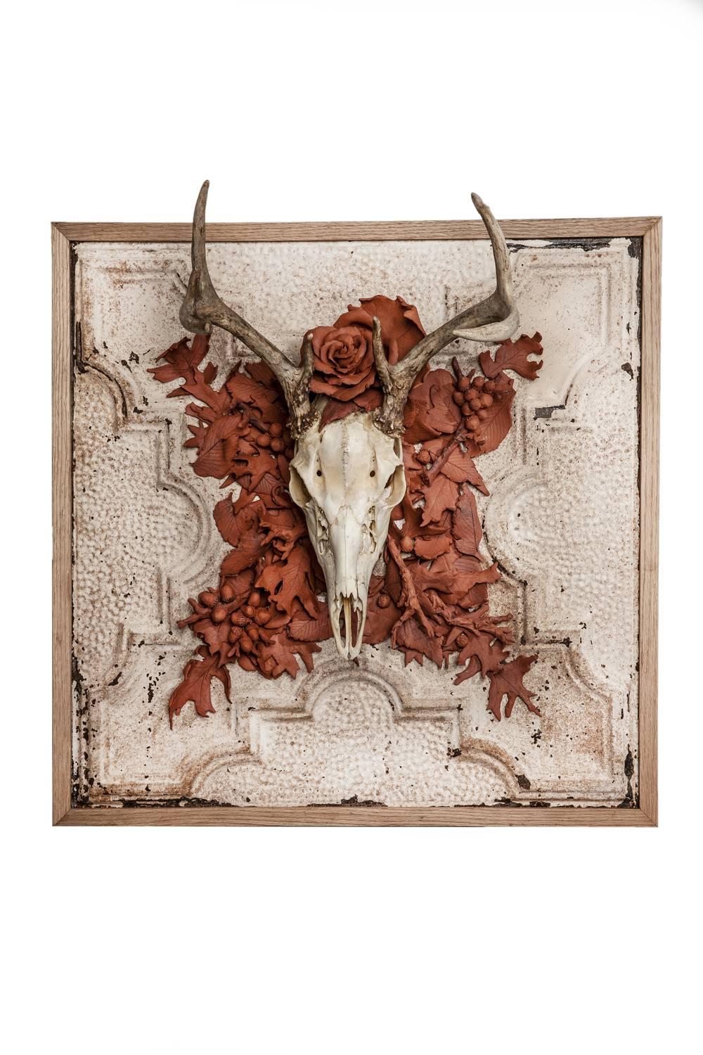 Fall is a sculpture by artist Marcy Lally. The piece is made of a Deer skull with handmade ceramic terracotta leaves on vintage ceiling tin. 
In an expression of the autumnal season, an assemblage of varied leaf casings have been put together with
