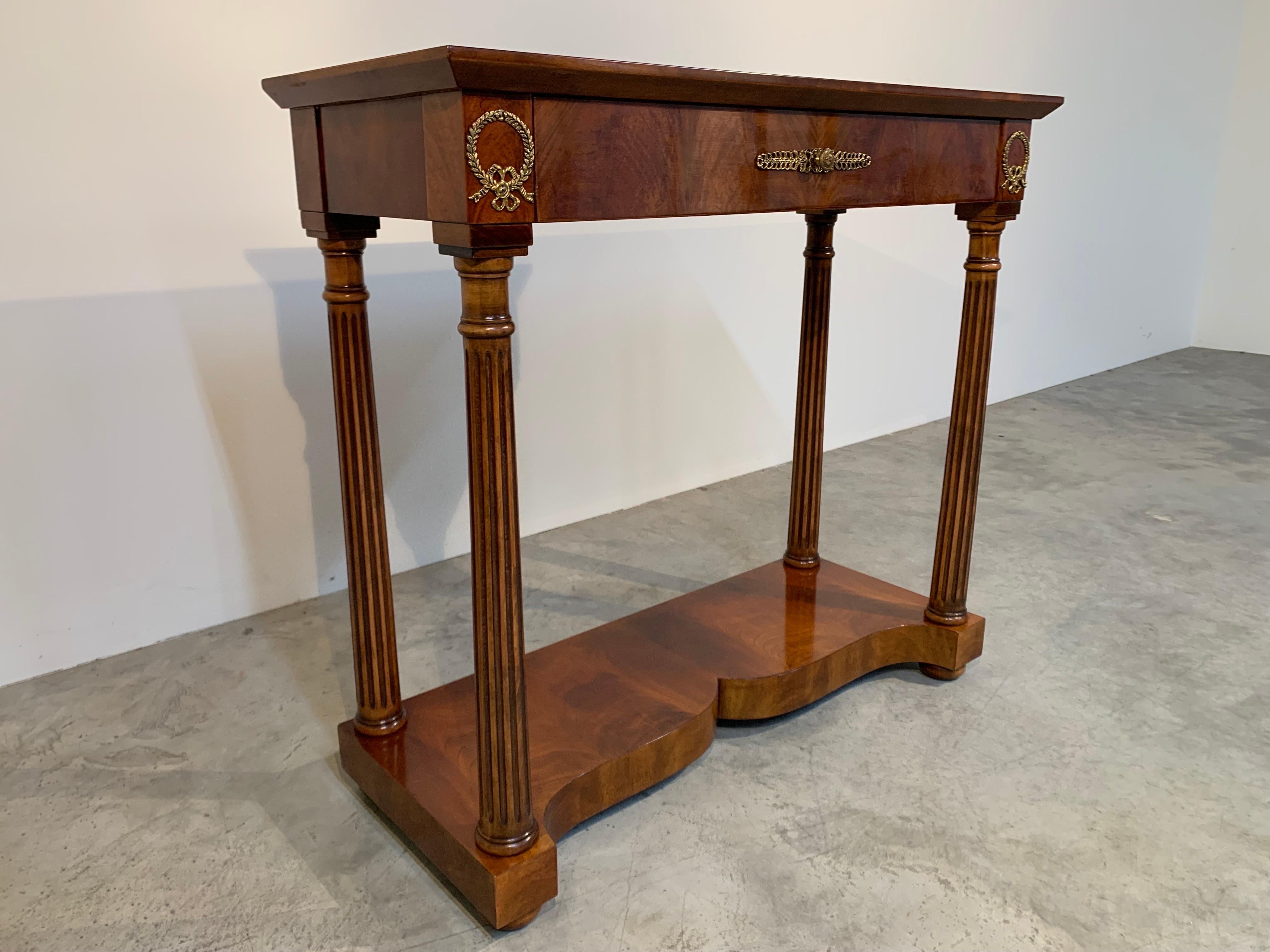 A beautiful mahogany console table having brass pulls and accents produced by marelli serafino
-Italy circa 2005. 
Solid, quality construction with sculpted lines and details. 
In outstanding condition.