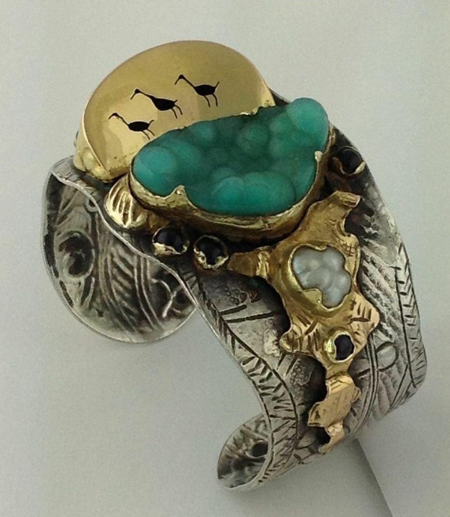 Margaret Barnaby sterling silver and 18K yellow gold cuff bracelet.

Marked: BARNABY STERLING 18K 94111.

Chasing and repousse techniques applied.

Ducks on a Pond theme.

Stones include:
Candala Chrysoprase, pearl and amethyst. 

Measures: 5 5/8
