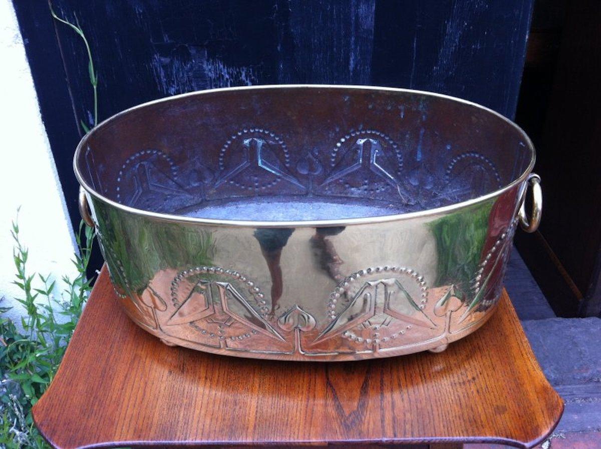 Margaret Gilmour attributed in the style of Talwin Morris. 
An Arts & Crafts Glasgow school brass planter with embossed kissing love birds.
  