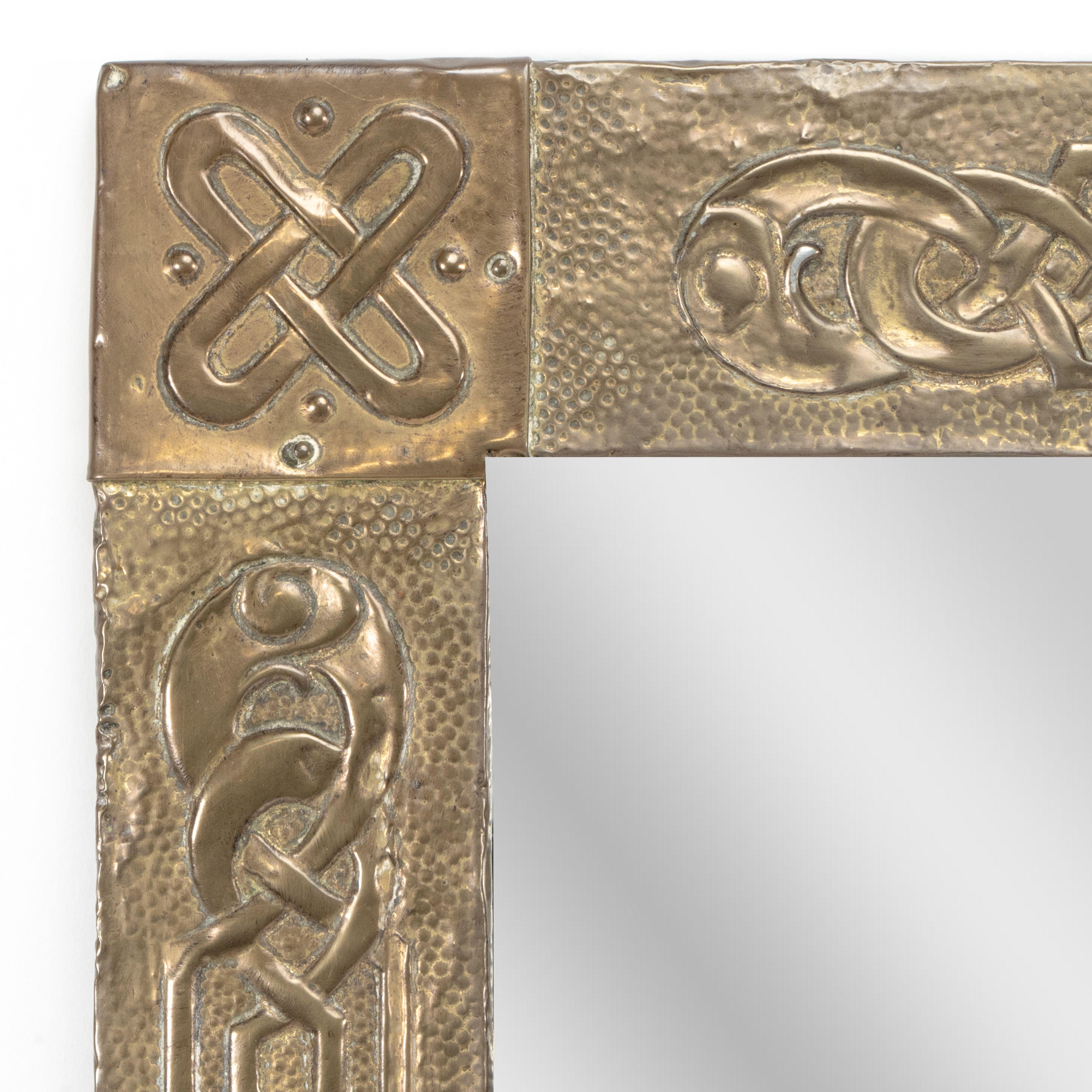 An Arts and Crafts oblong brass mirror attributed to Margaret Gilmour School with wonderful Celtic interlacing typical to her hand.