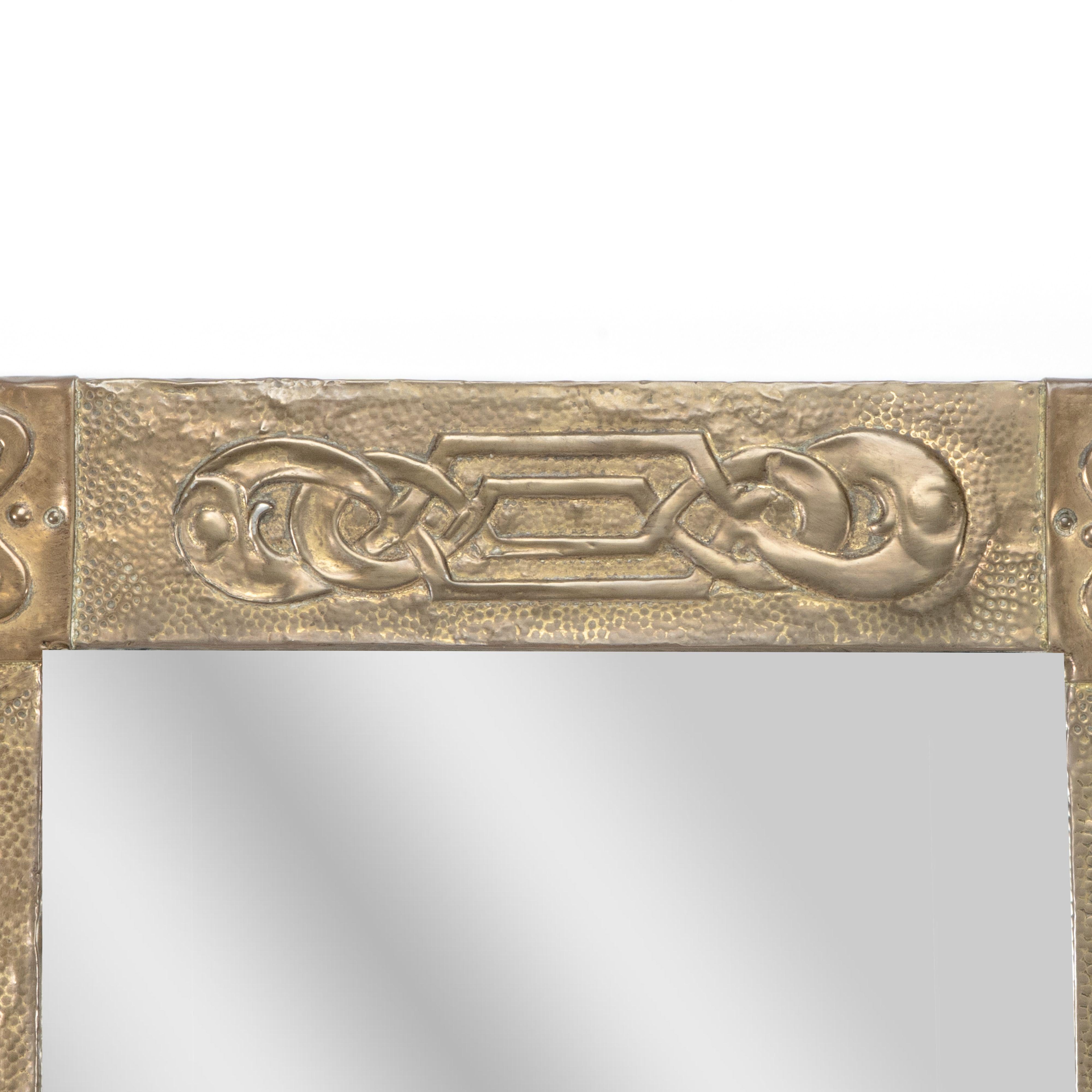 Early 20th Century Margaret Gilmour School. An Arts and Crafts oblong brass mirror