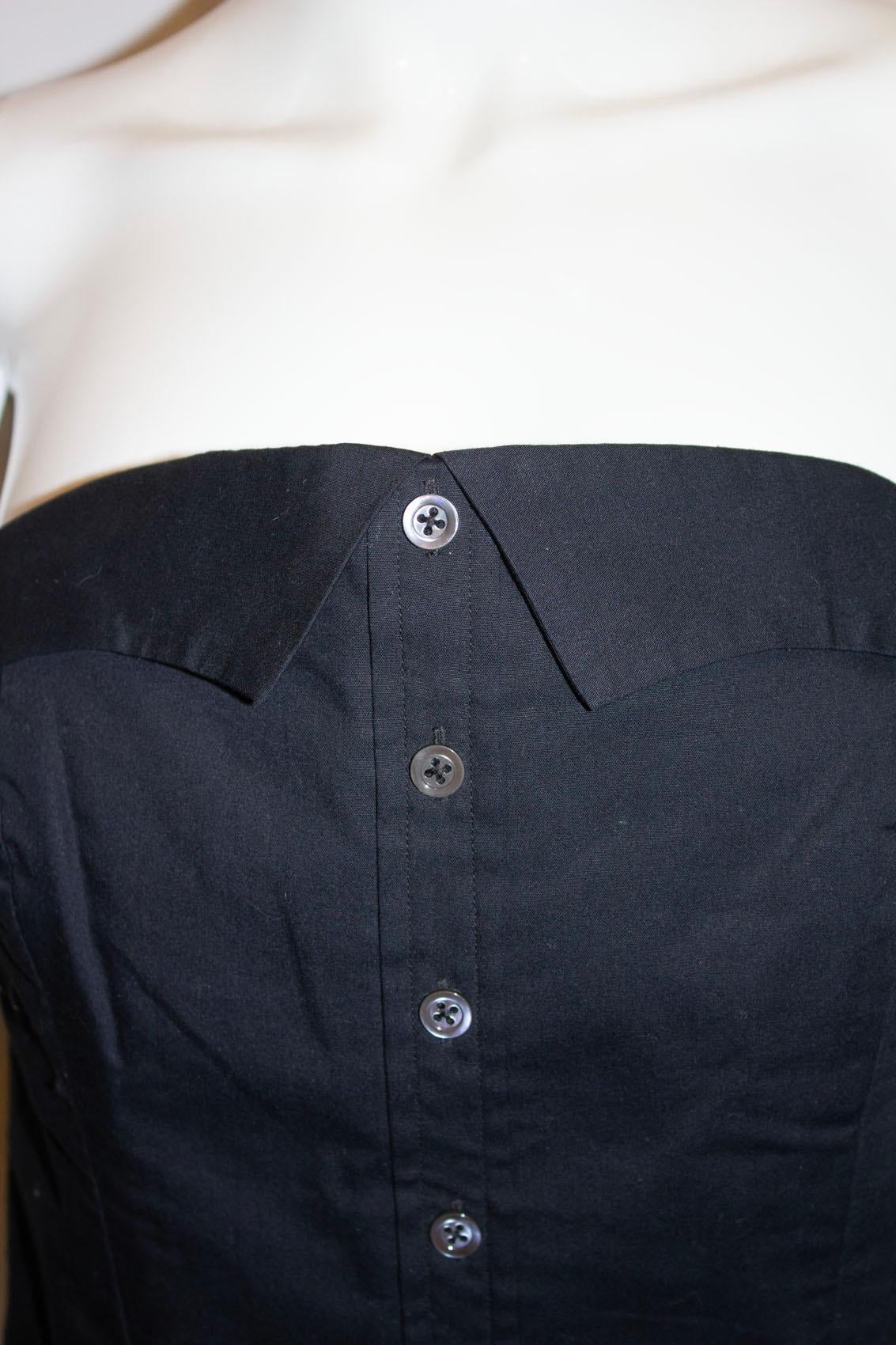  A great addition to any wardrobe, this chic cotton bustier by Margaret Howell.  In a black cotton , it has an attractive button detail on the front, fastening with hooks and eyes at the back. 
It is fully lined with an internal waist belt.
Size 10